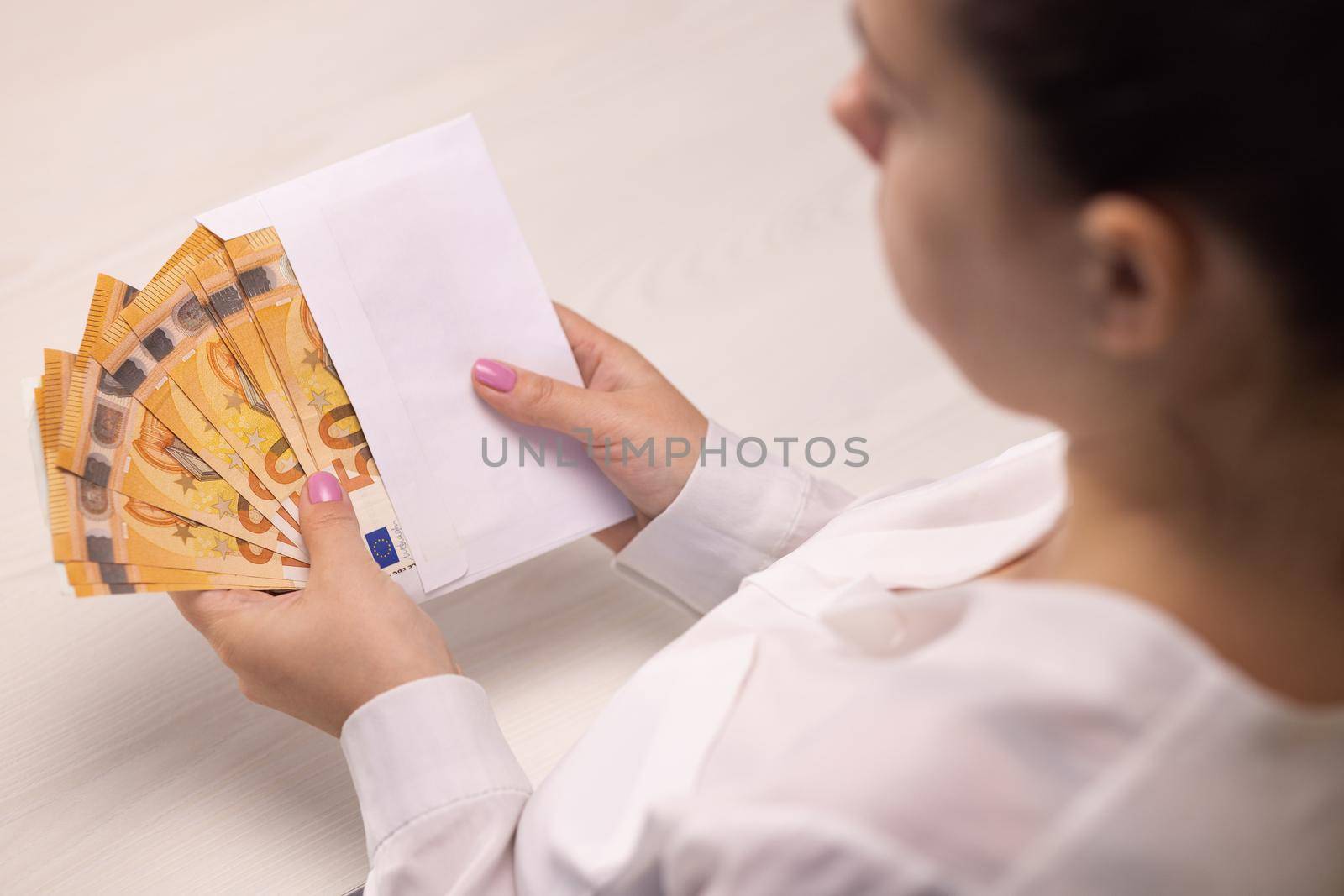 Female hands checking euro bills in envelope, witness bribing, illegal salary. Corruption. Tax cheating. Takes an envelope with 50 euro banknotes.