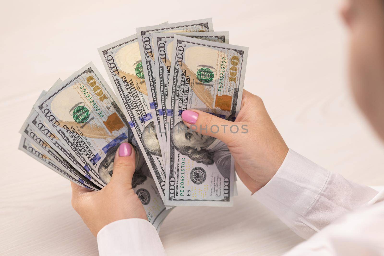 Overhead top view woman counts of 100 american dollars money. Cash banknotes. Bribe and corruption concept. Finance and investment. Currency exchange of one hundred bills. Money counting.