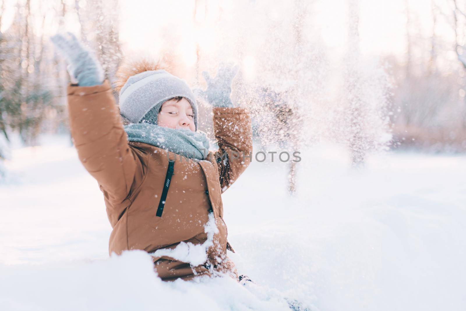 The boy throws snow in winter lifestyle . Winter walks. An article about children's winter leisure. Entertainments