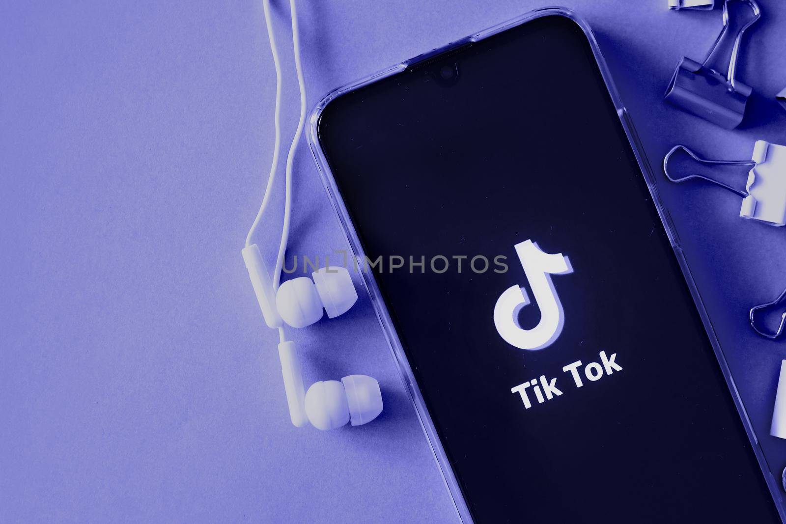 Tver, Russia-April 9, 2020, the tik tok logo on the smartphone screen with headphones. Tick-Tok icon. logo of the current app. Tiktok social network. Demonstrating the colors of 2022 - Very Peri