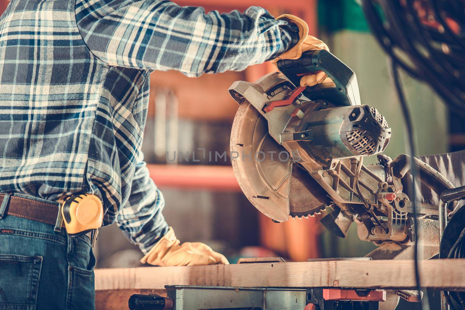 Wood Worker Using Powerful Circular Saw Close Up Photo. Construction Industry Theme.