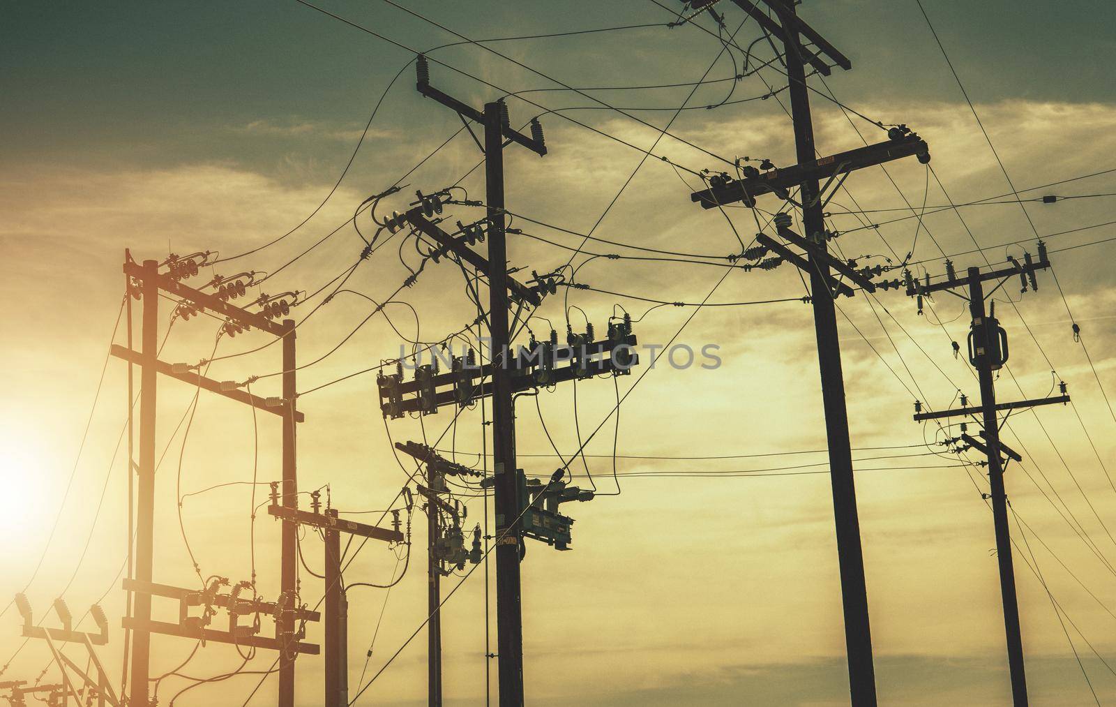 Aged Wooden Electric Poles and High Voltage Infrastructure. Power Industry Theme.