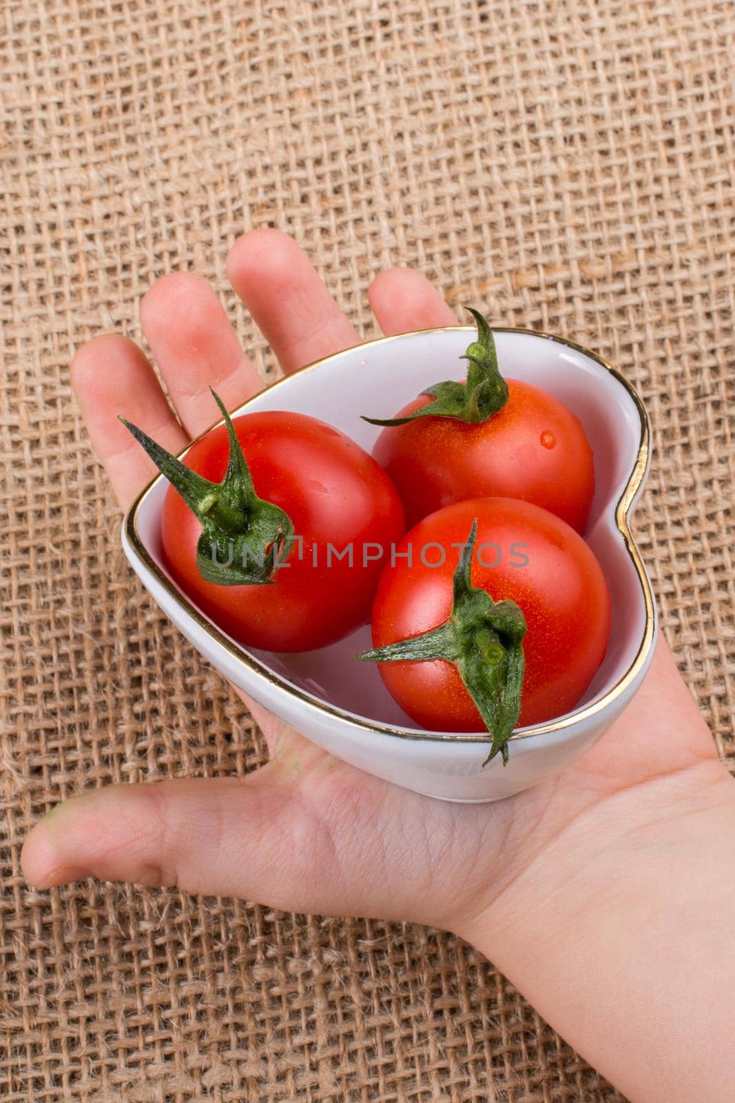 Red ripe cherry tomatos  tomatos in heart shaped bowl