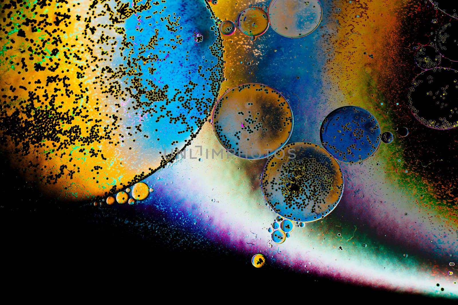 Macro shot of water oil emulsion over colored background by berkay