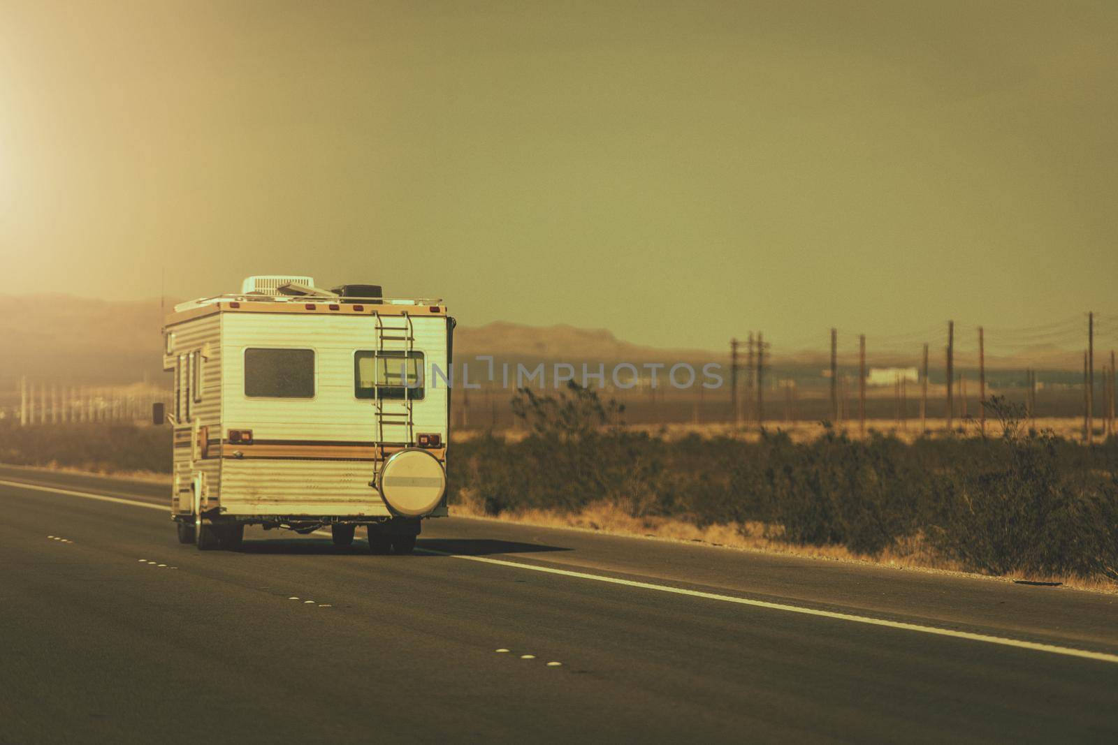 RV Road Trip. Vintage Aged Camper Van on a Highway. Recreational Vehicles Theme.