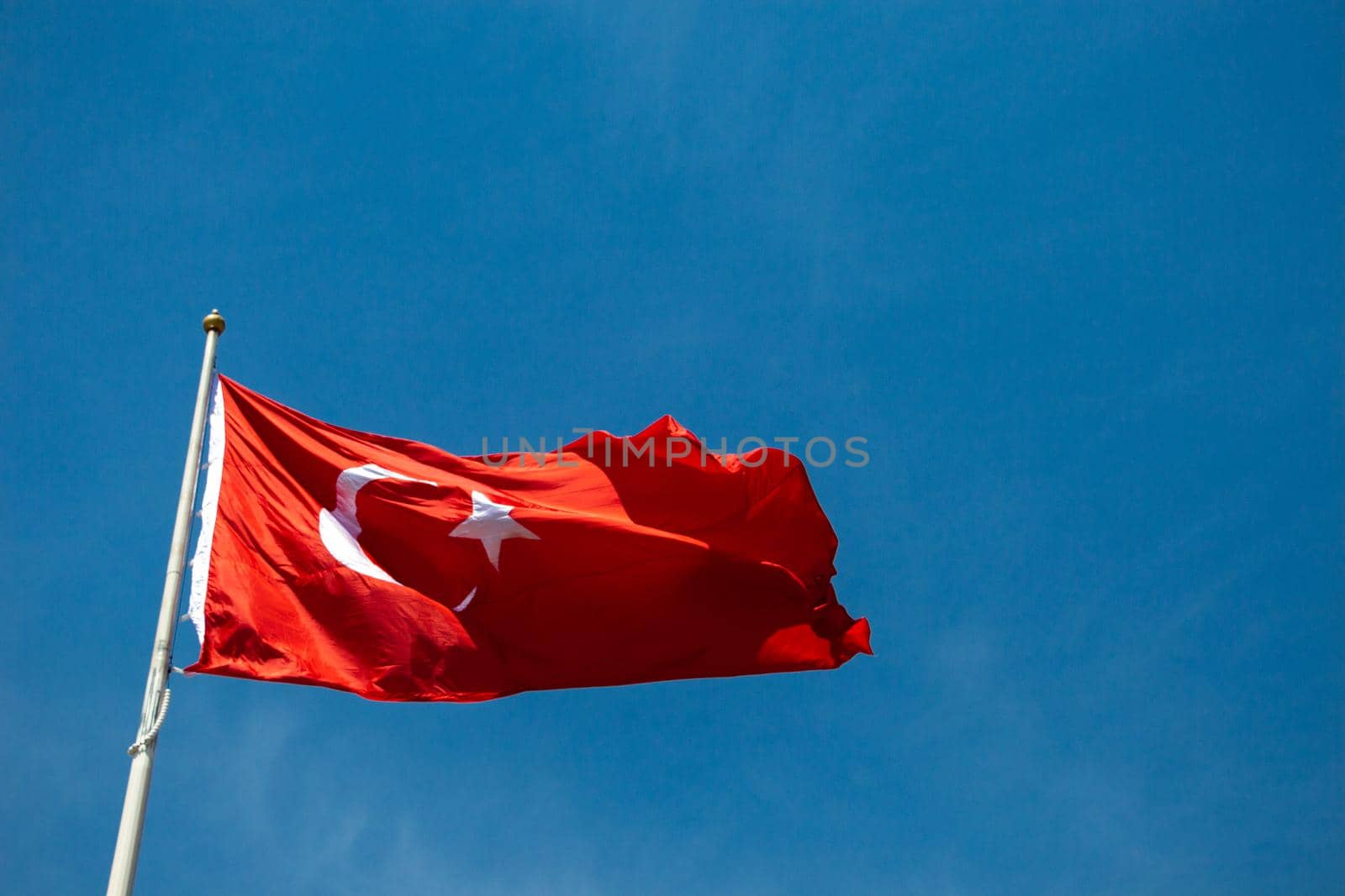 Turkish national flag with white star and moon in sky by berkay