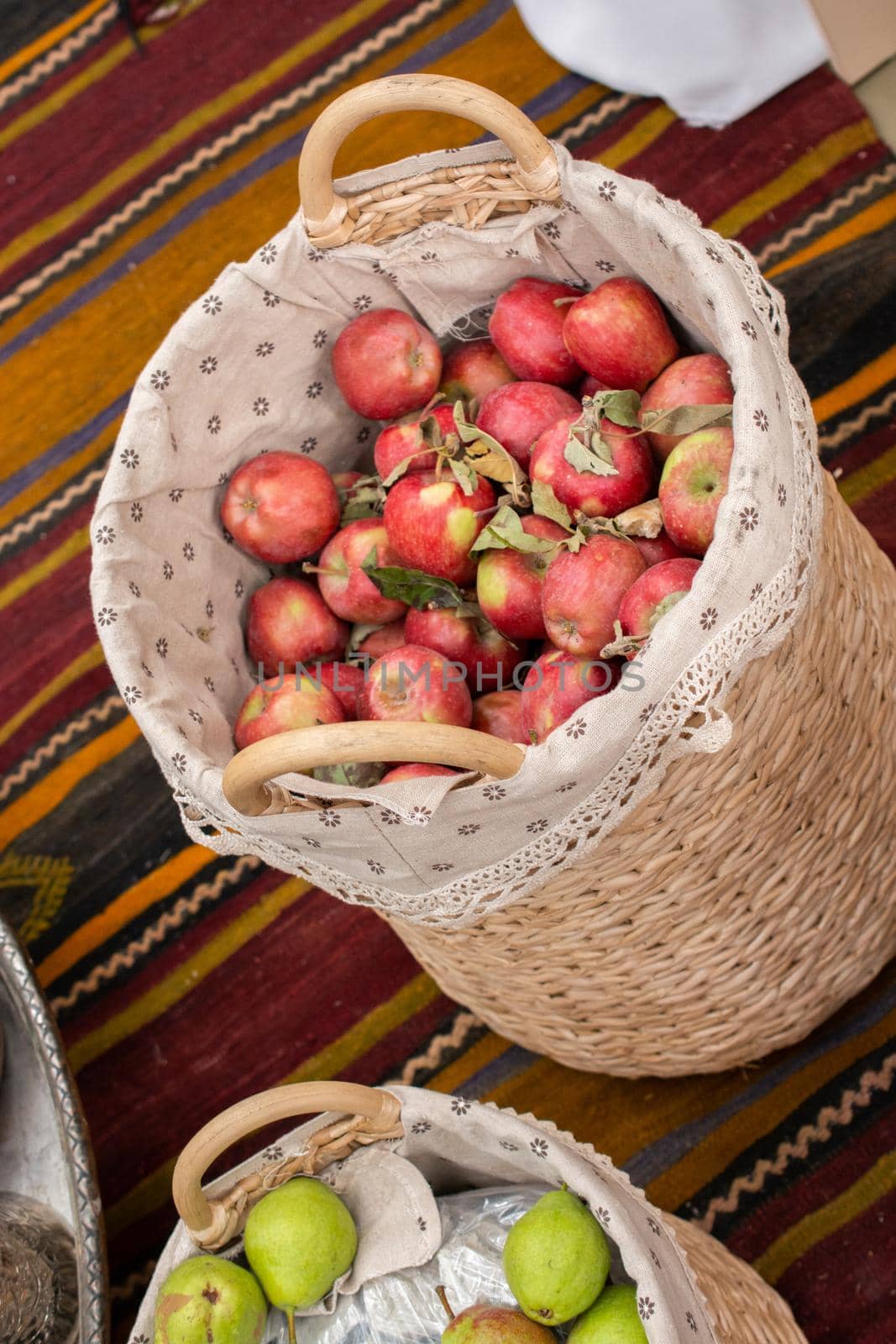 Red and green apples in straw baskets in display