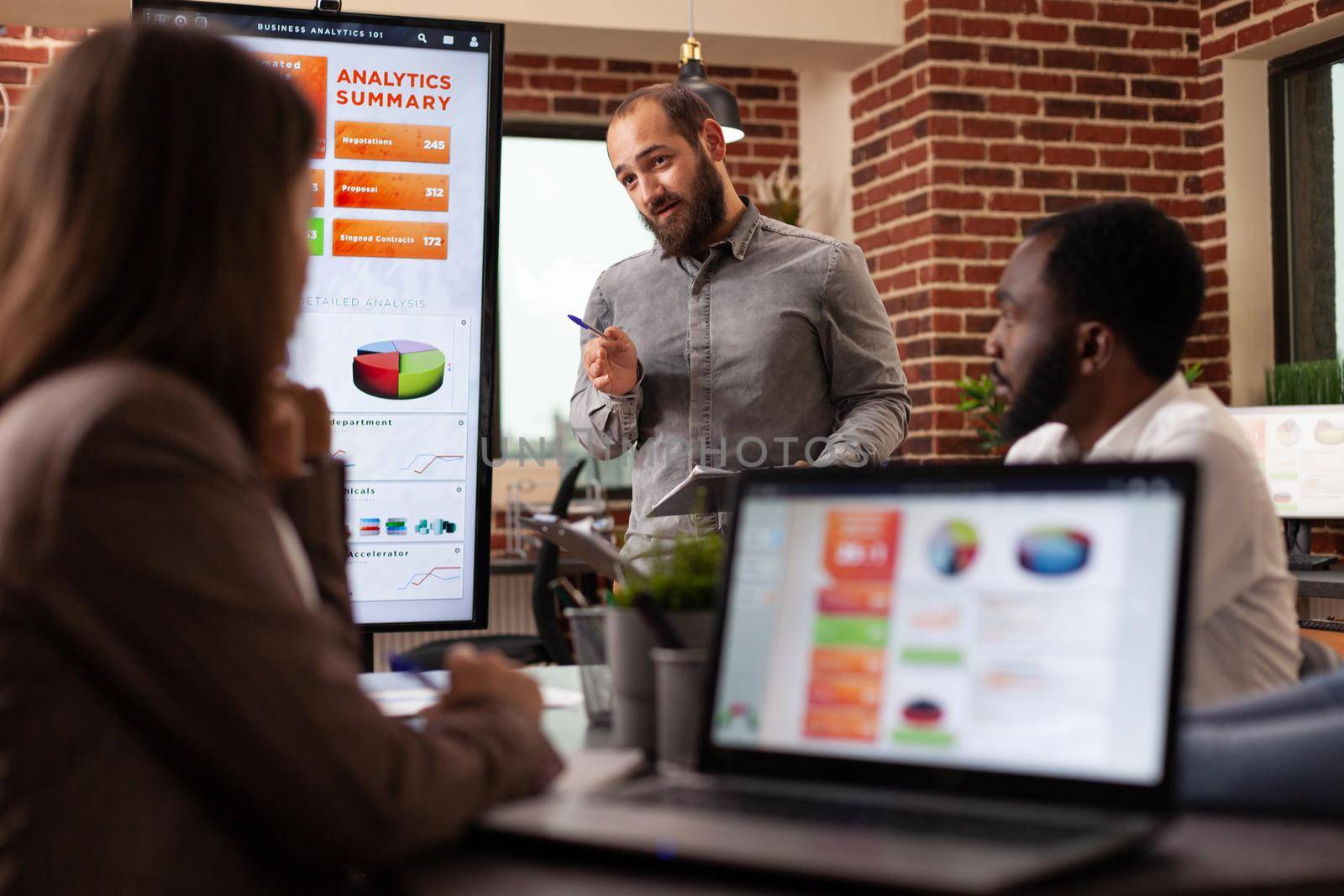 Businesswoman discussing management presentation brainstorming ideas for company project sitting at meeting table with collegue in startup office. Businesspeople planning financial strategy