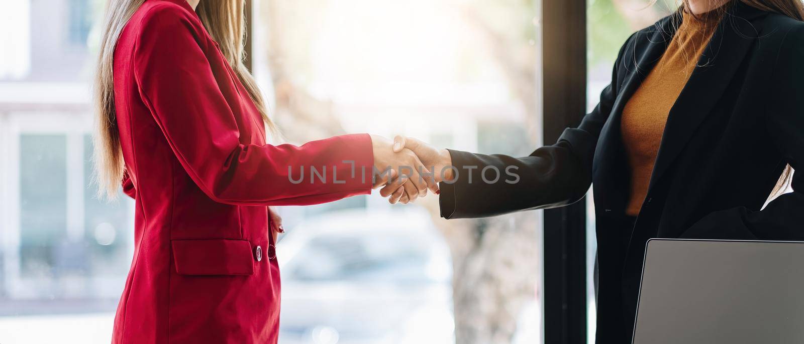 two businessman shake hands as hello in office closeup. Friend welcome, introduction, greet or thanks gesture, product advertisement, partnership approval, strike a bargain on deal concept by nateemee