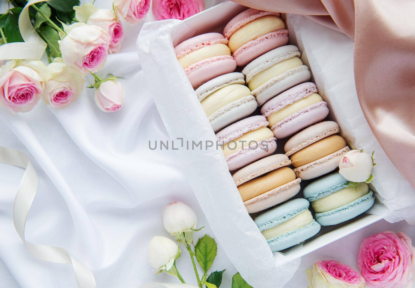 Colorful macaroons in a gift box and roses by Almaje