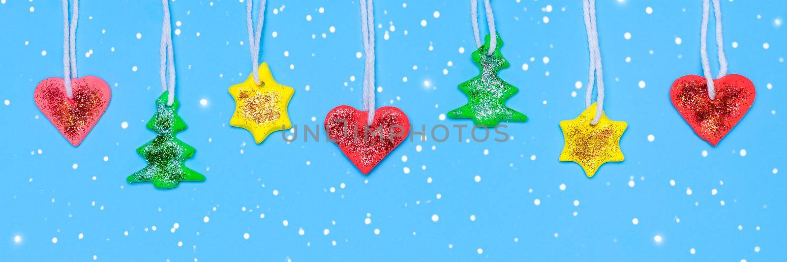 DIY Garland for Christmas tree. Fut tree, star and heart made from red, yellow and green Plasticine. Long Christmas or New Year banner. Plasticine craft concept.