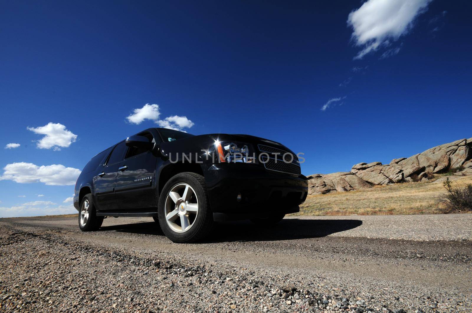 Large Black SUV on the Colorado Road. Wide Angle Photo. Summer Time in Colorado by welcomia