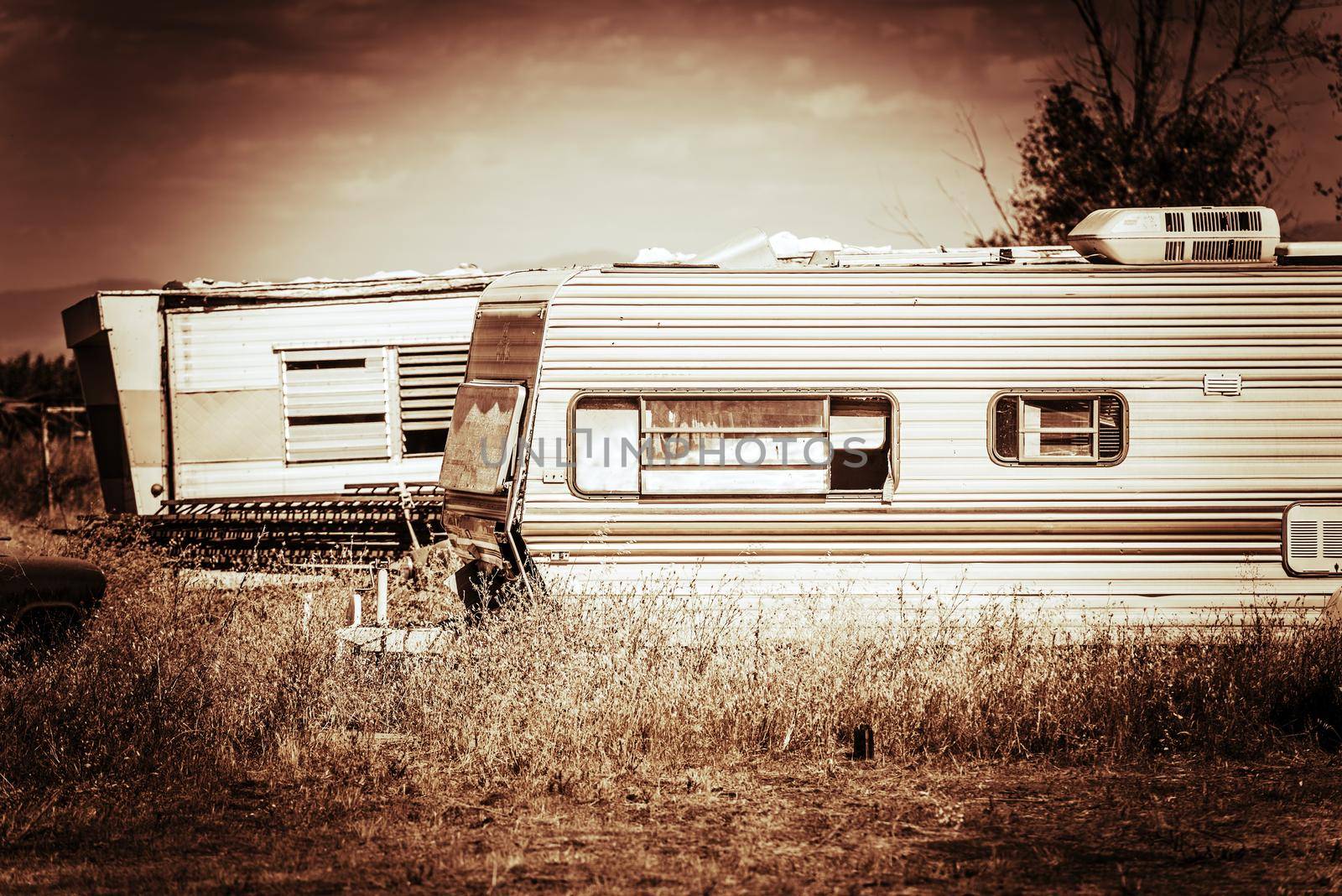 Old Rusty Campers in Some Rural American Area. Trailer Park Living. Browny Sepia Color Grading. by welcomia