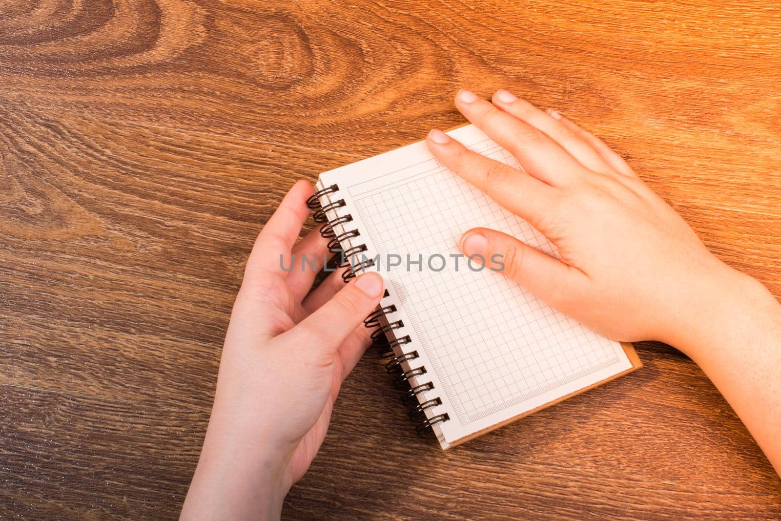 Notebook  in hand on a brown color background  by berkay