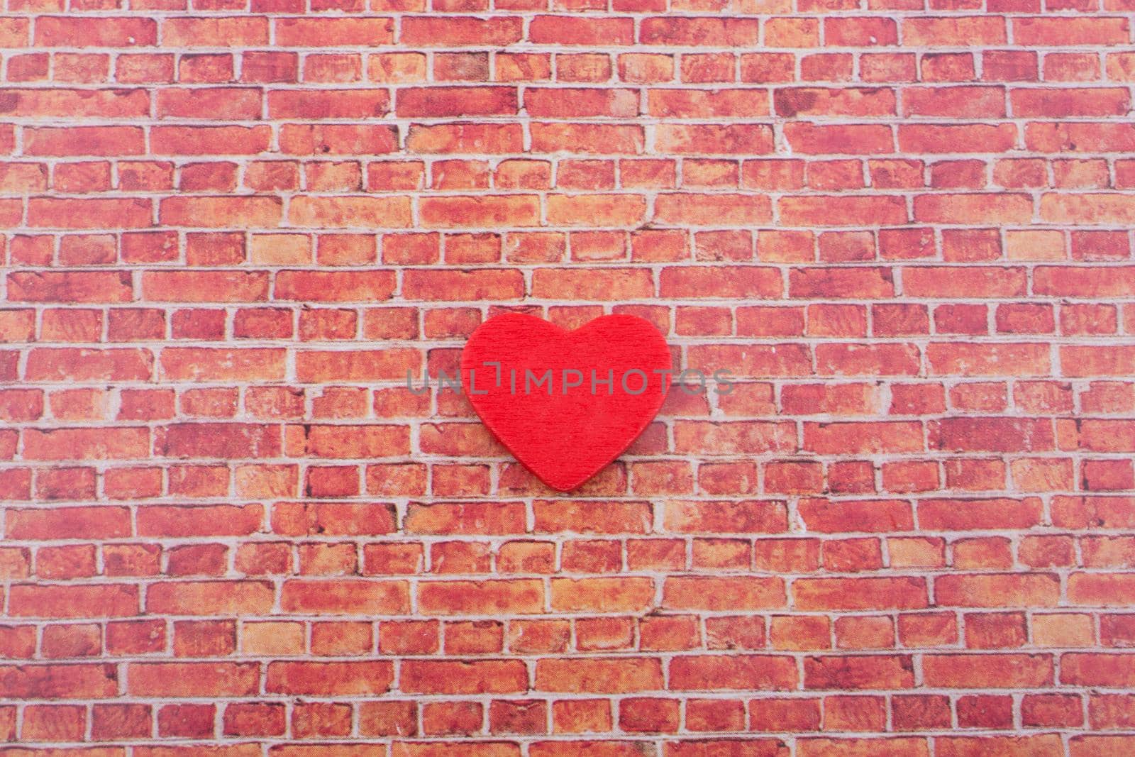 Red heart shape icon on a brick wall