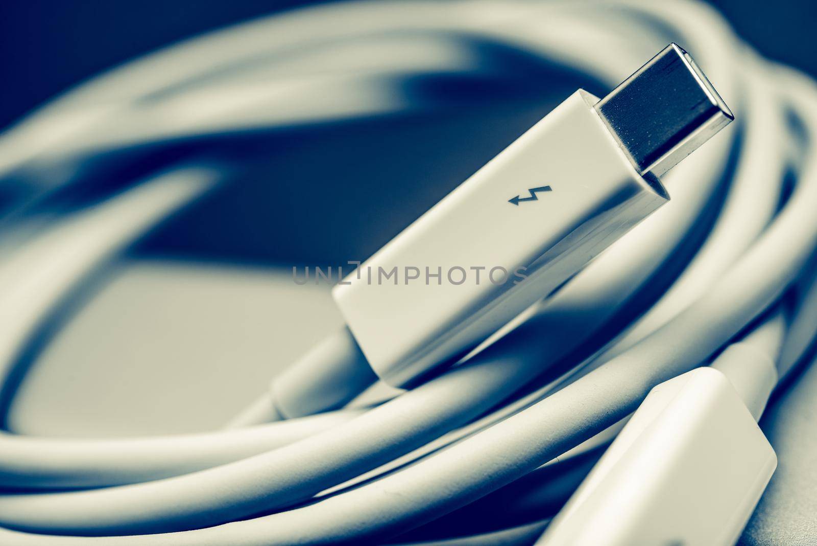 White Thunderbolt Cable Closeup Photo. Thunderbolt Data Transfer Cable.
