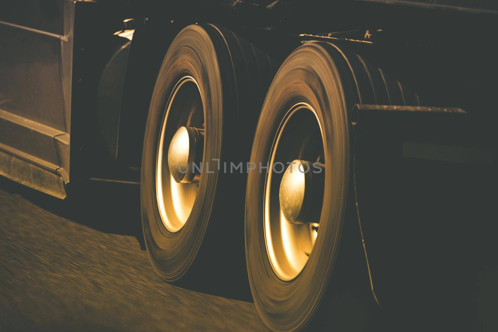 Spinning Semi Truck Wheels Closeup Photo. Browny Color Grading. Trucking and Transportation Theme. by welcomia