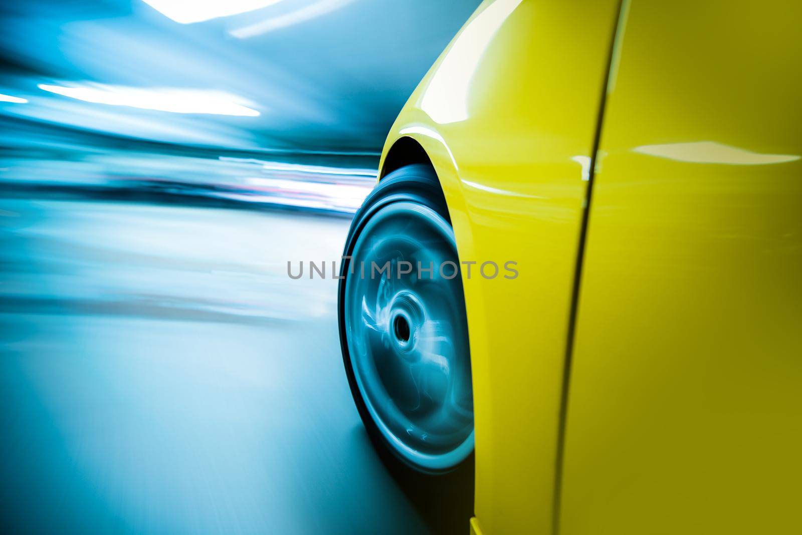 Speeding Car at Night. Long Exposure City Drive. Front Wheel in Motion Closeup. Motion Blur Transportation Concept