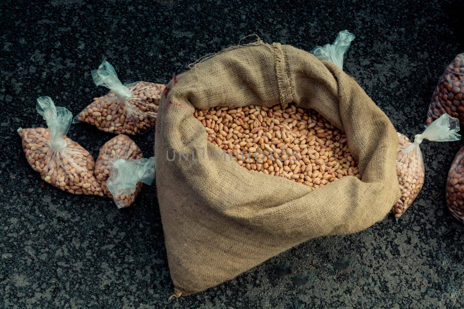 Unshelled peanuts in a straw sack on display by berkay