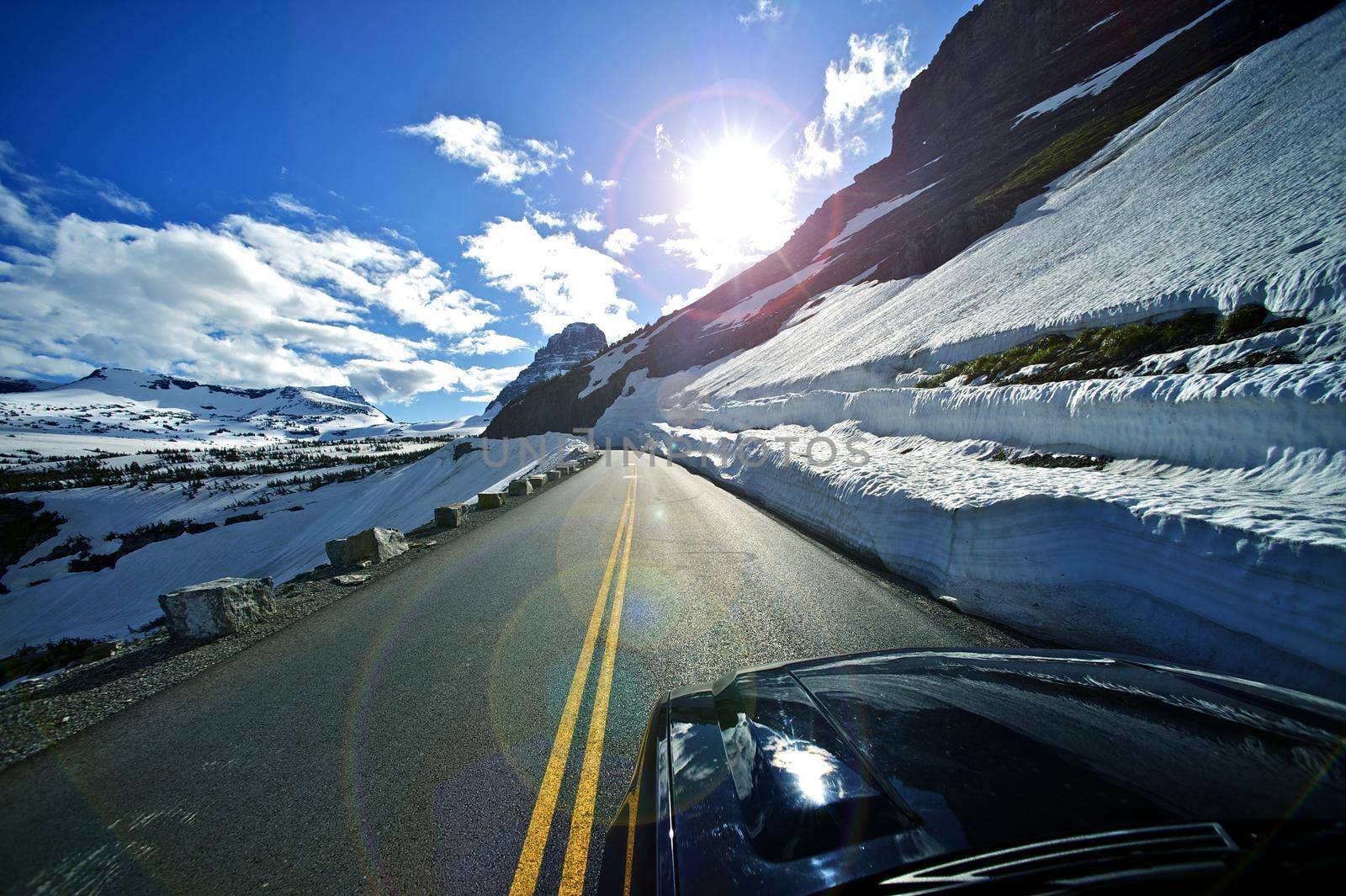 Ridge Road Drive - Road-To-The-Sun in the Glacier National Park in Montana, U.S.A. Snowfields and Rocks. Montana Landscape. by welcomia