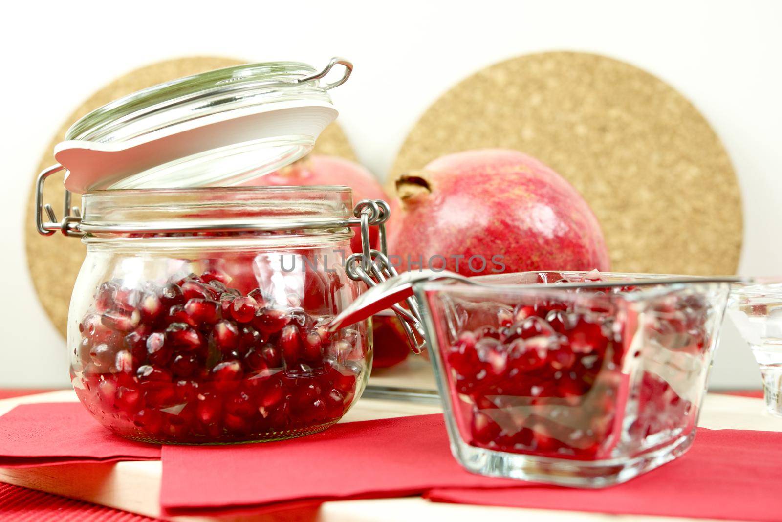 Pomegranate in Glass with Fresh Pomegranate in the Back. Fruits Photo Collection. by welcomia