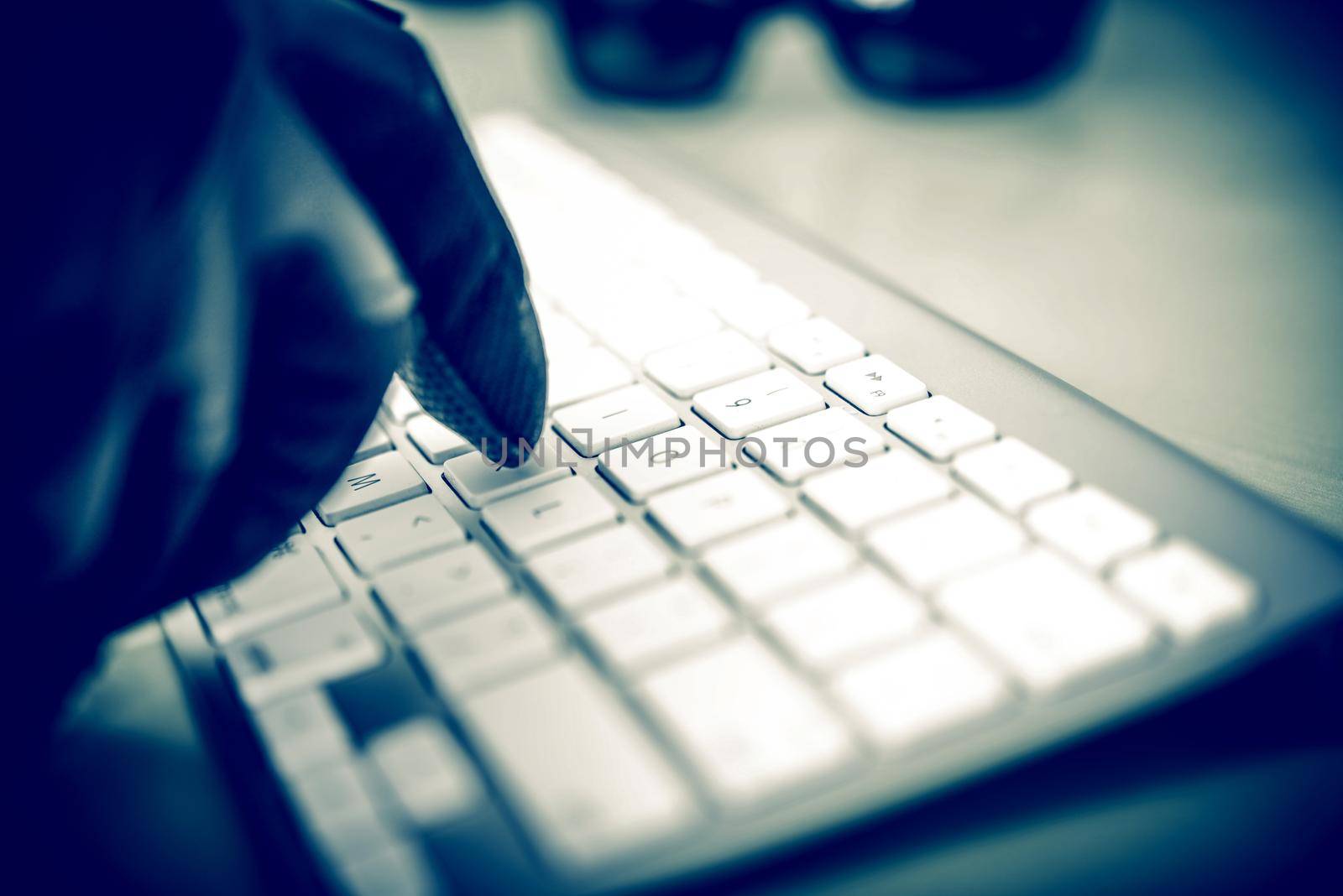 Hacker in Work. Hacker Hand in Black Glove Typing on the Keyboard. Closeup Photo Concept.  by welcomia
