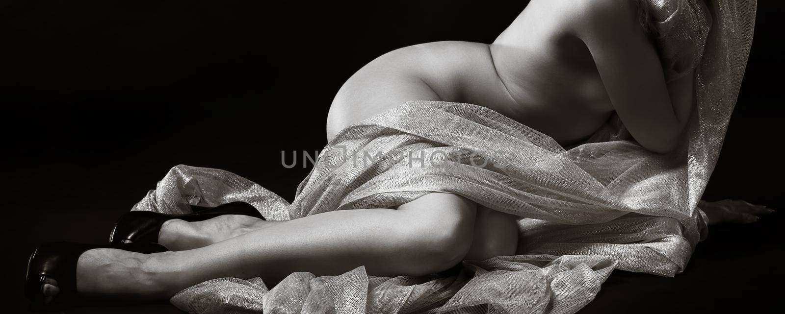 Nude woman posing in studio with a golden shawl by palinchak