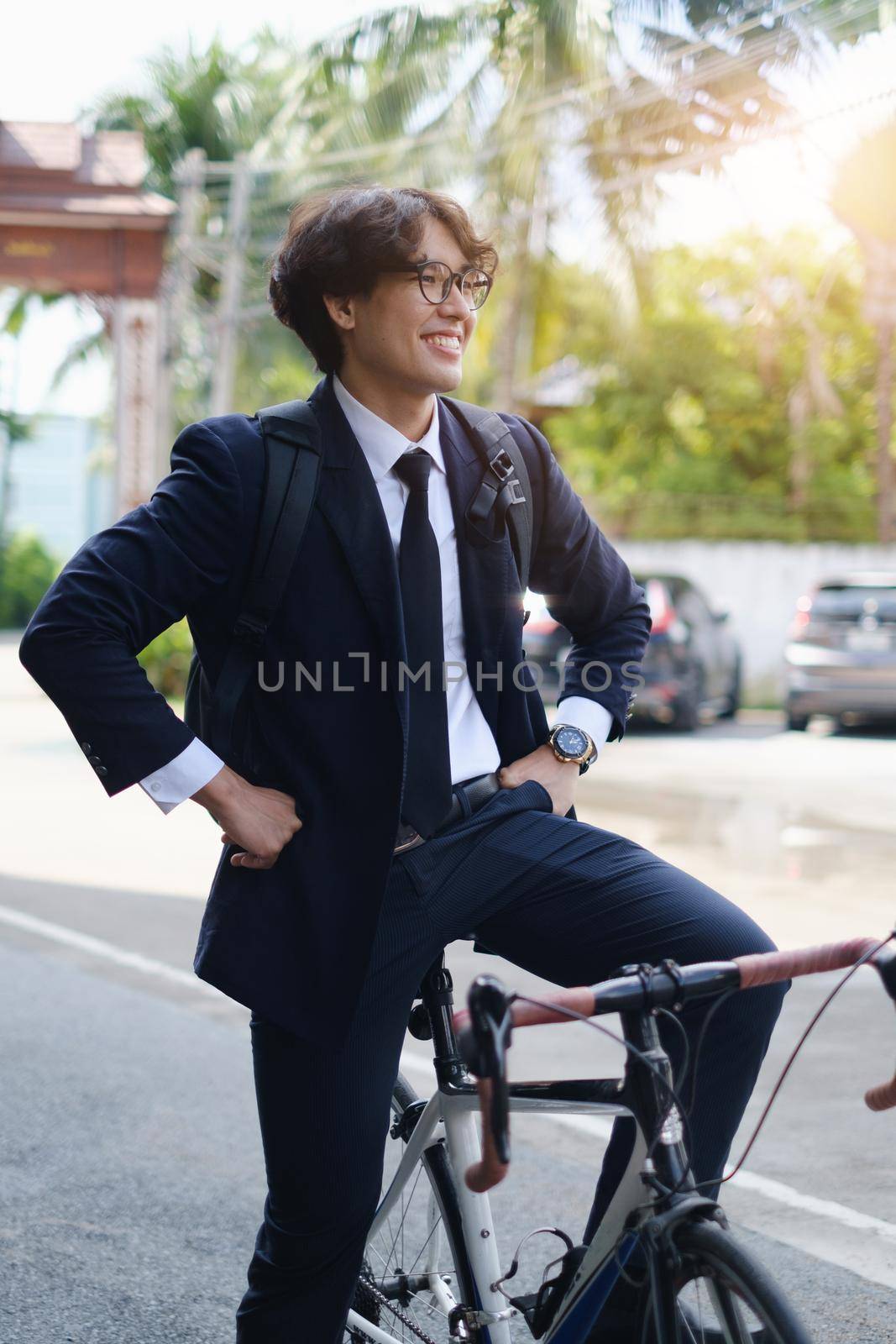 Handsome young asian businessman in suit have smiling with bicycle go to work at morning by itchaznong
