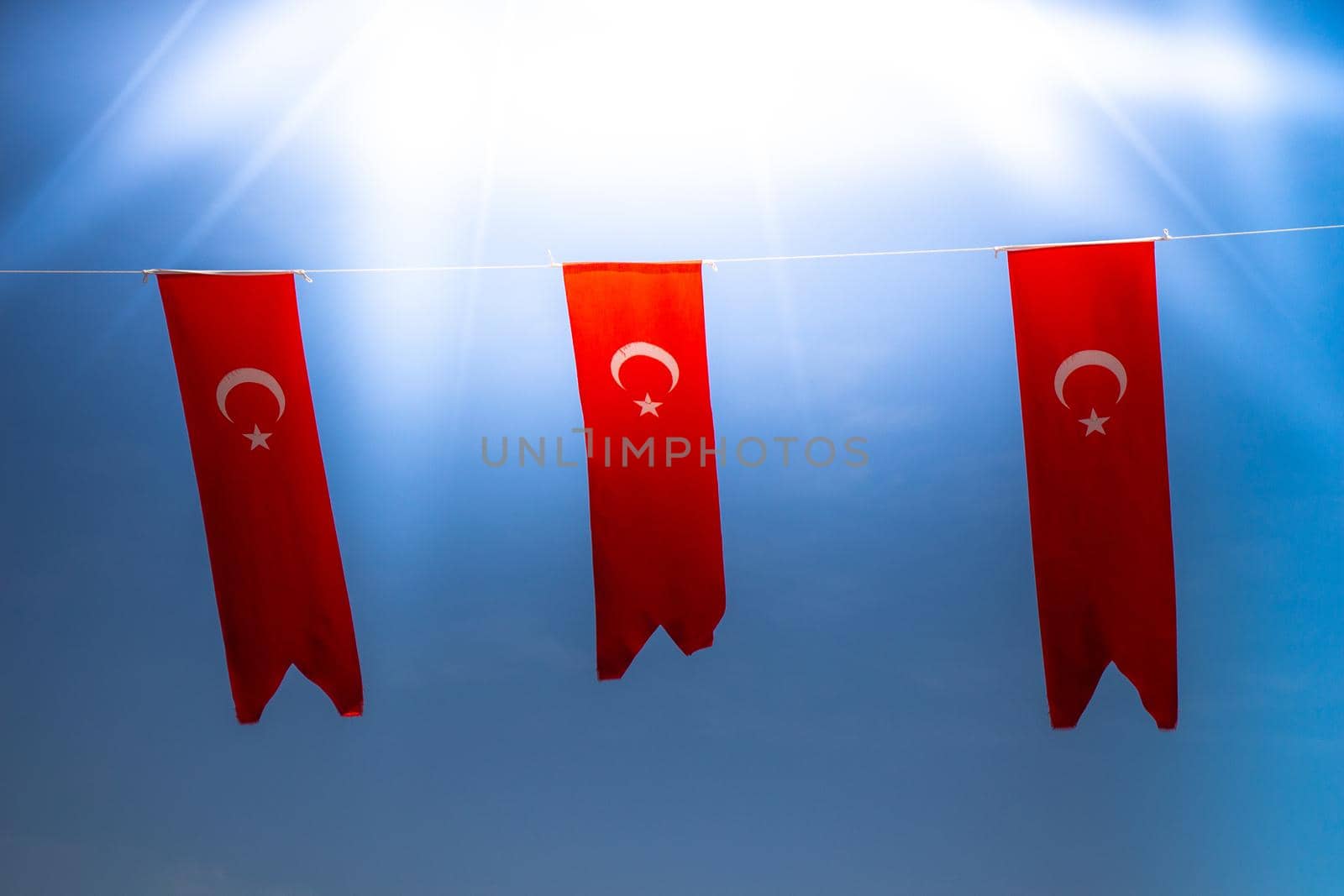 Turkish national flags with white star and moon in sky by berkay