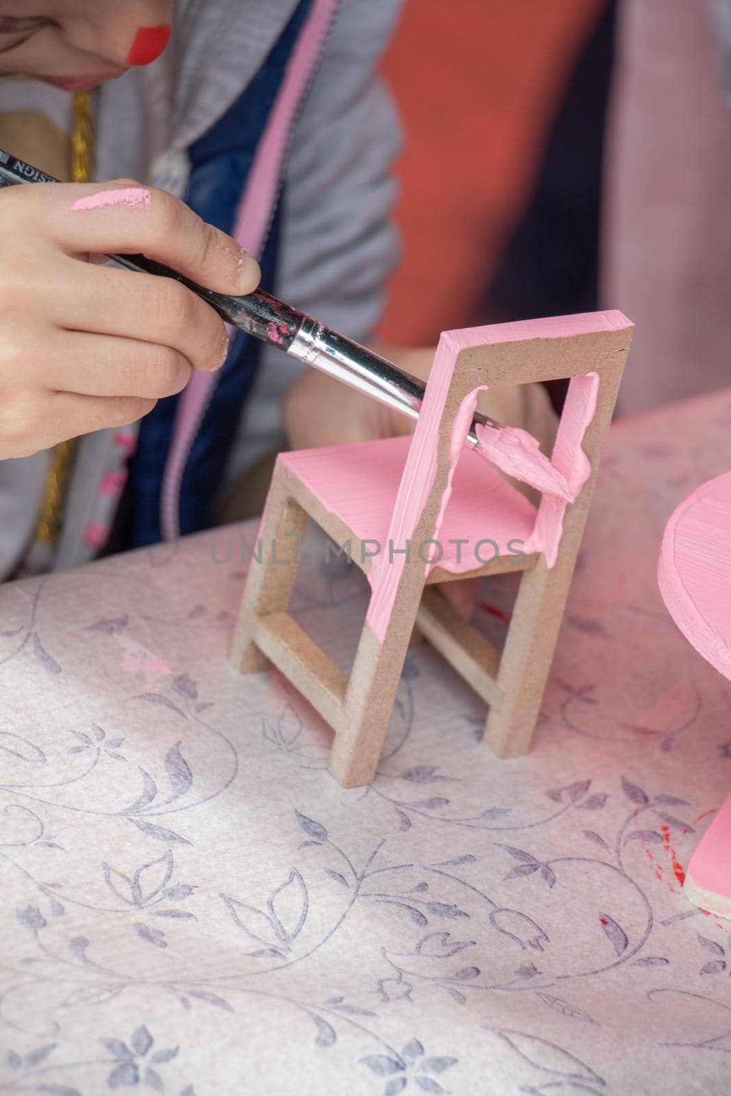 Young children decorating handmade wooden chair