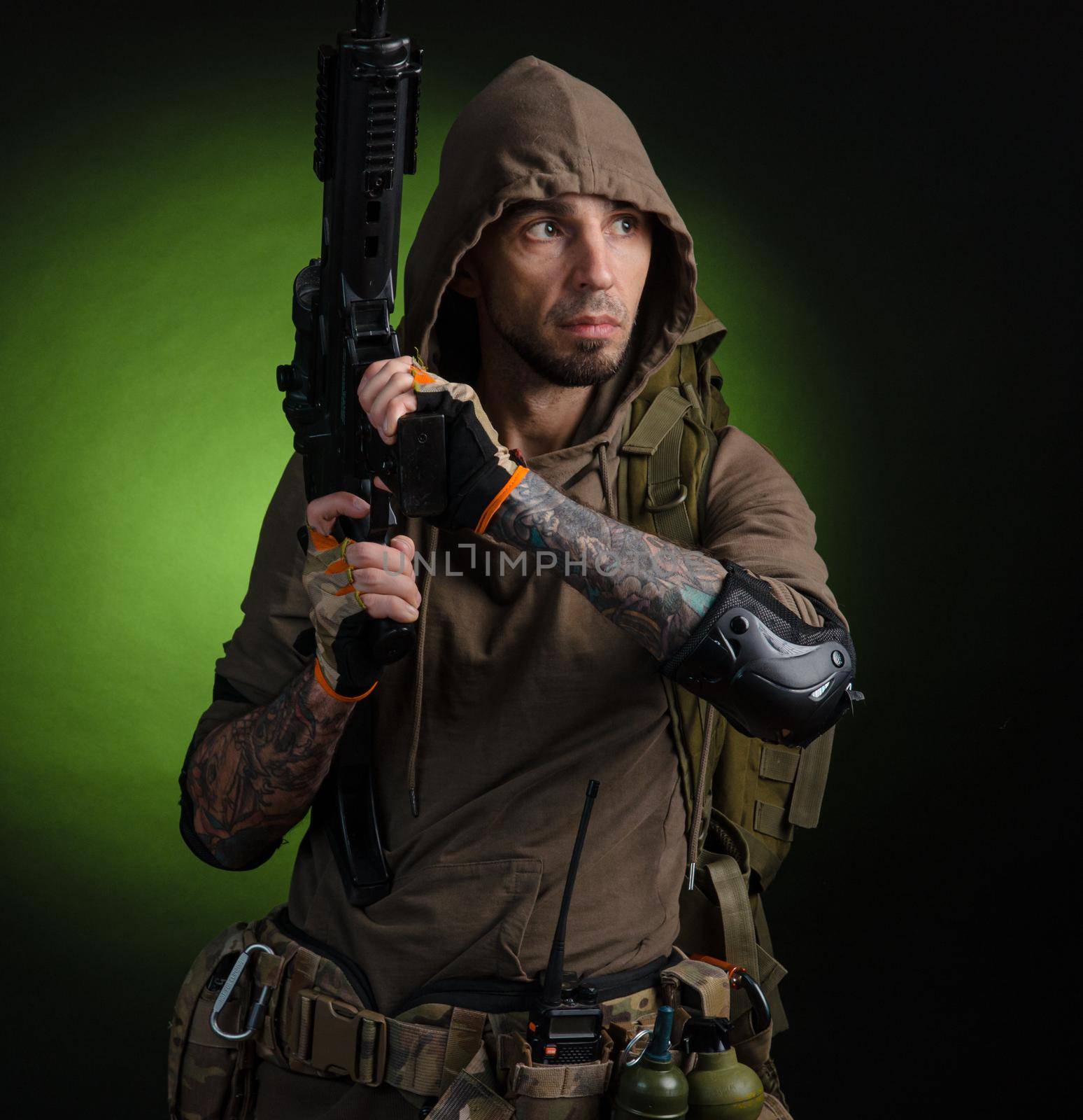 man Stalker with a gun with an optical sight and a backpack on a dark background by Rotozey