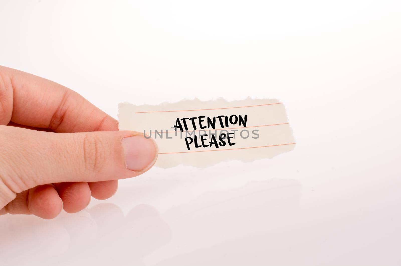 Hand holding a white paper  with attention wording on white