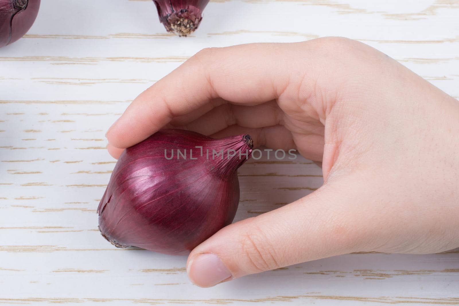 Whole red onion bulbs in brown on wooden background