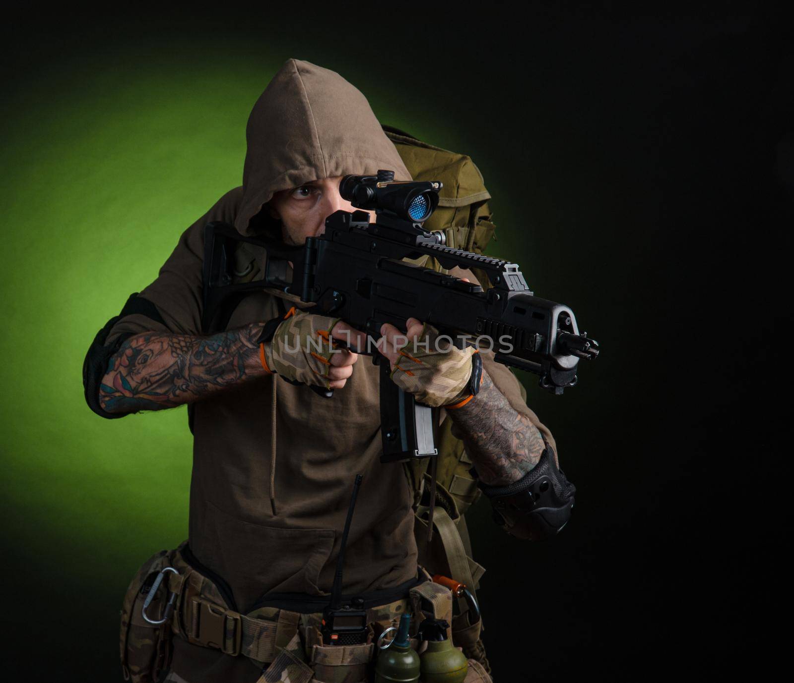 man Stalker with a gun with an optical sight and a backpack on a dark background by Rotozey