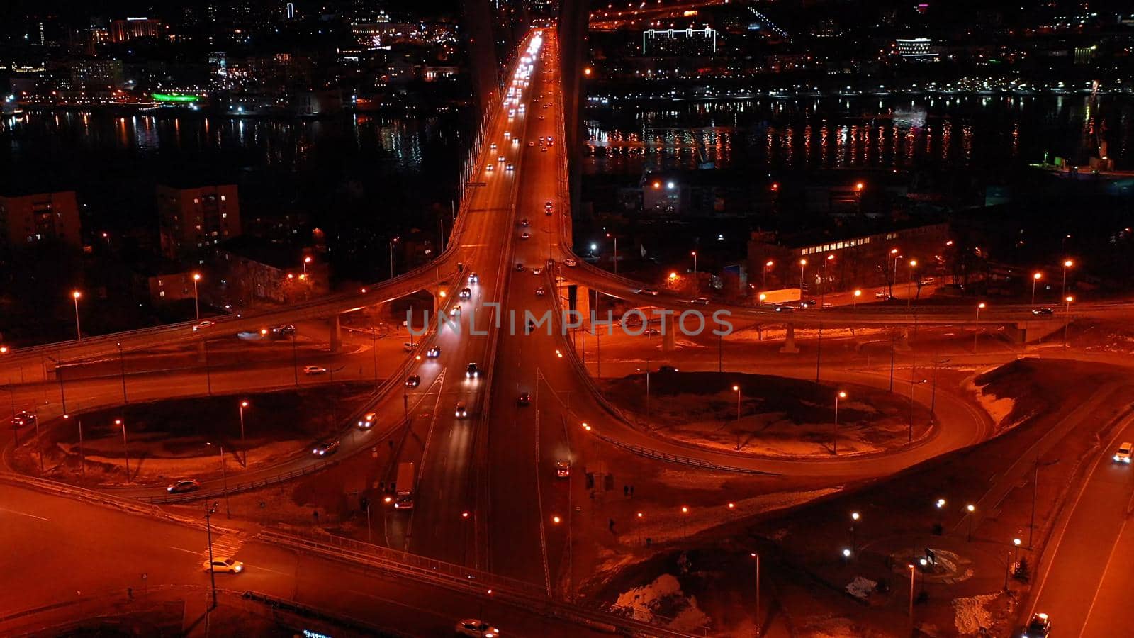 Aerial view of the night landscape with a view of the road over the Golden Bridge. Vladivostok, Russia