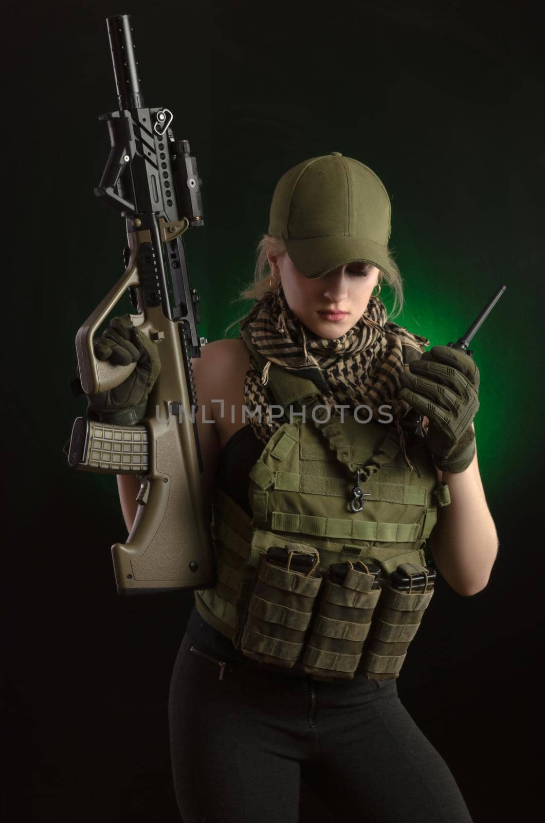 the girl in military special clothes posing with a gun in his hands on a dark background in the haze by Rotozey