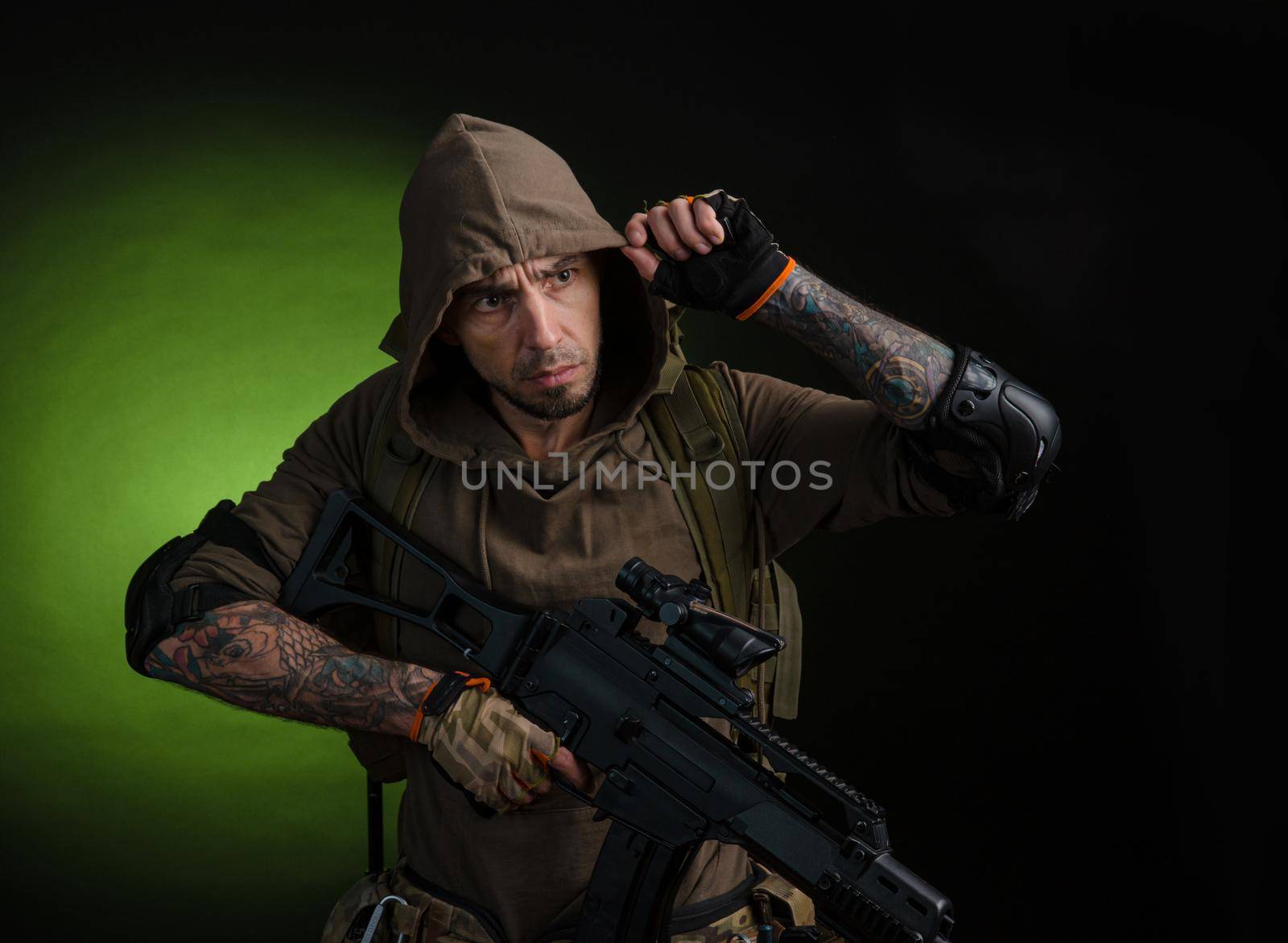 man Stalker with a gun with an optical sight and a backpack on a dark background with emotions looking, aiming, watching, sneaking by Rotozey