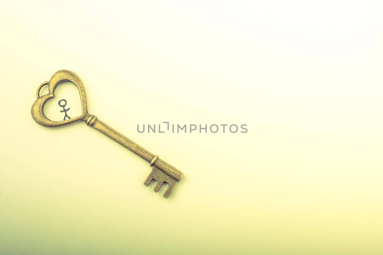 Tiny stick man and  heart shaped key on white
