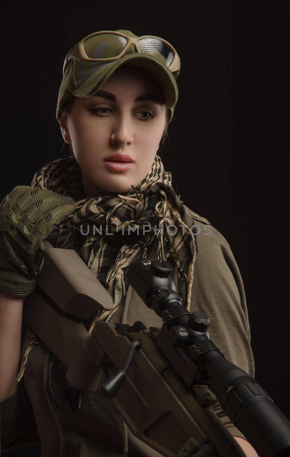 the girl in military special clothes posing with a gun in his hands on a dark background in the haze by Rotozey