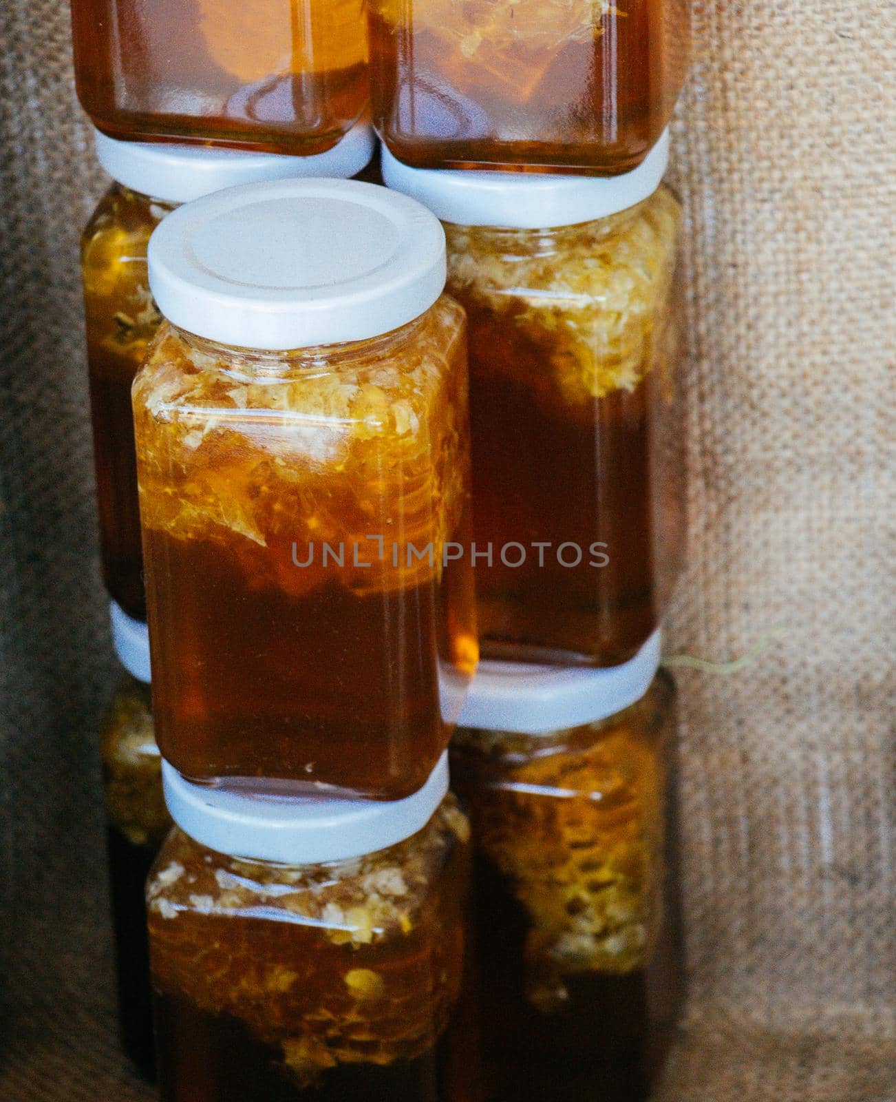 Glass jar of honey set with lid closeup  by berkay