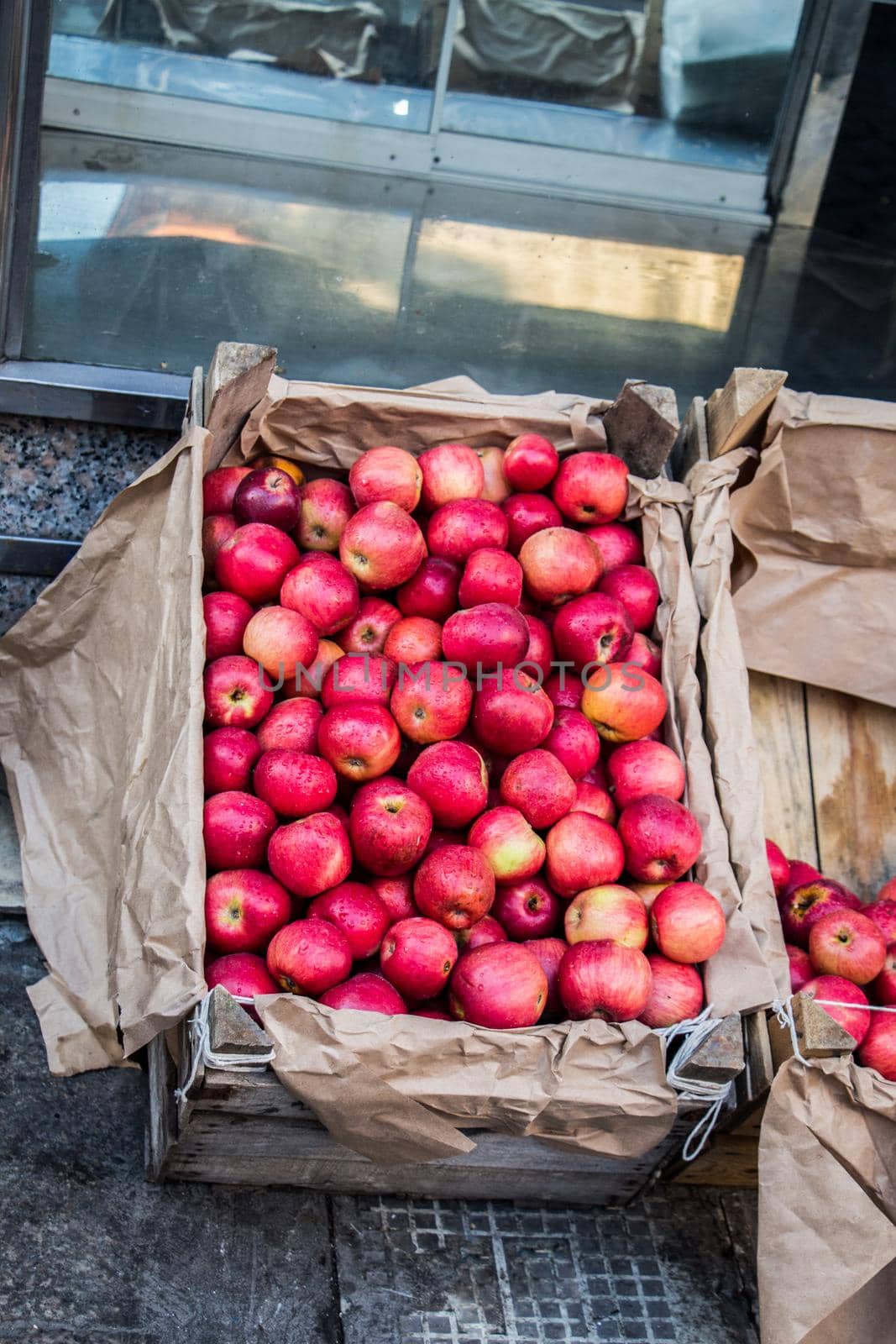 Fresh organic red apples are in wooden crate at bazaar