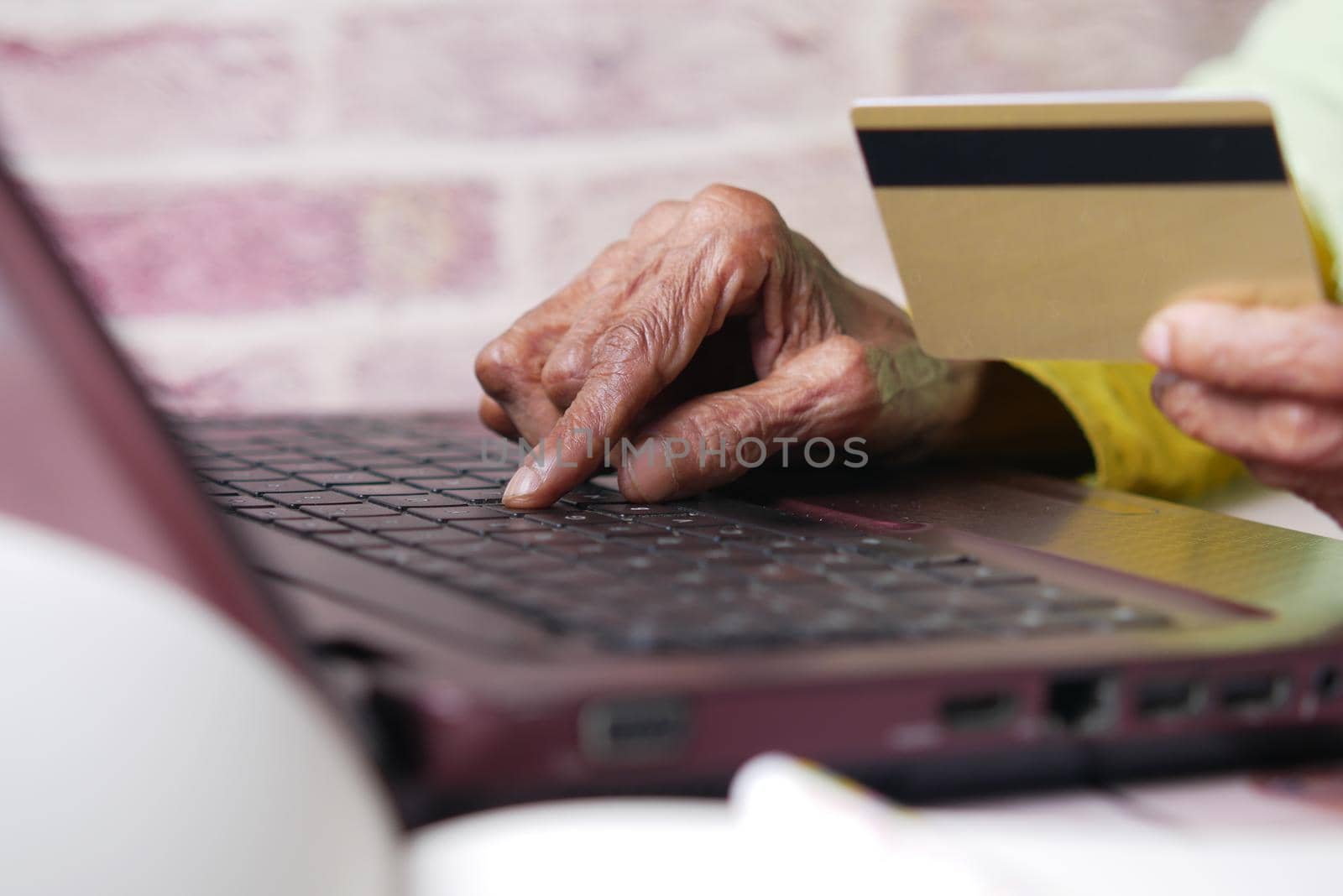 senior women holding credit card and using laptop shopping online ,