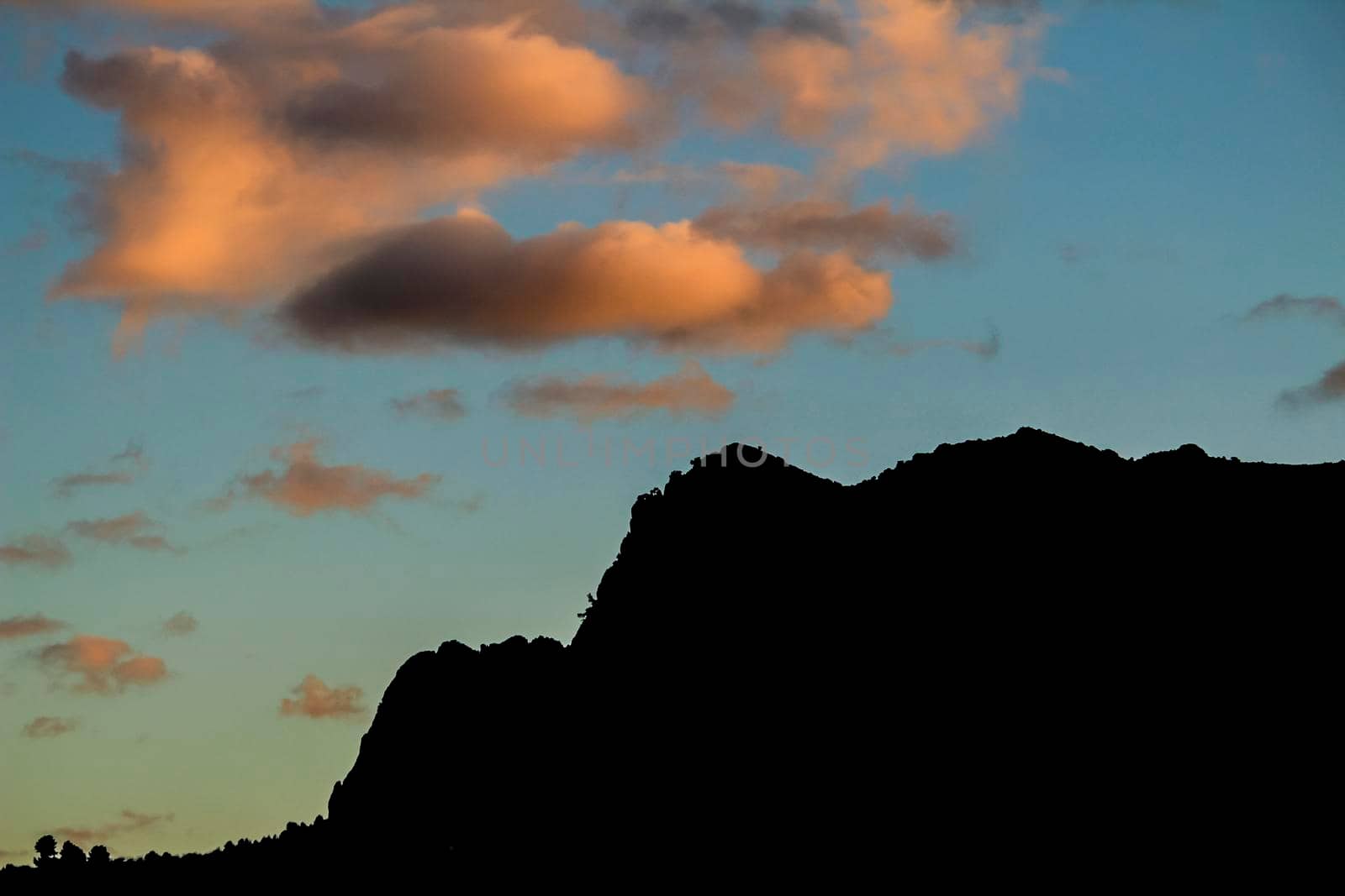 Spectacular sunset with colorful clouds and silhouette of mountains in Guadalest, Alicante, Spain