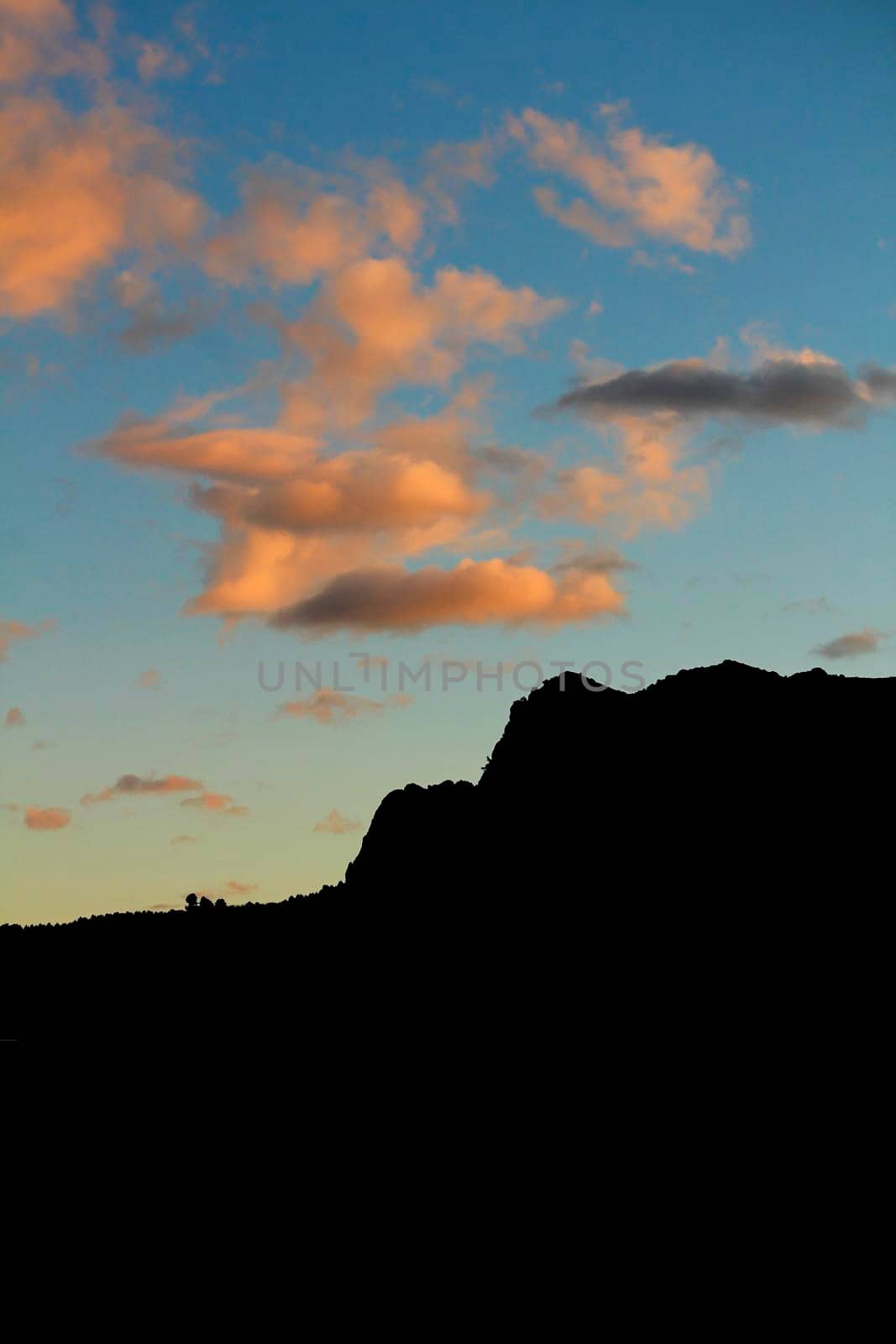 Spectacular sunset with colorful clouds and silhouette of mountains in Guadalest, Alicante, Spain