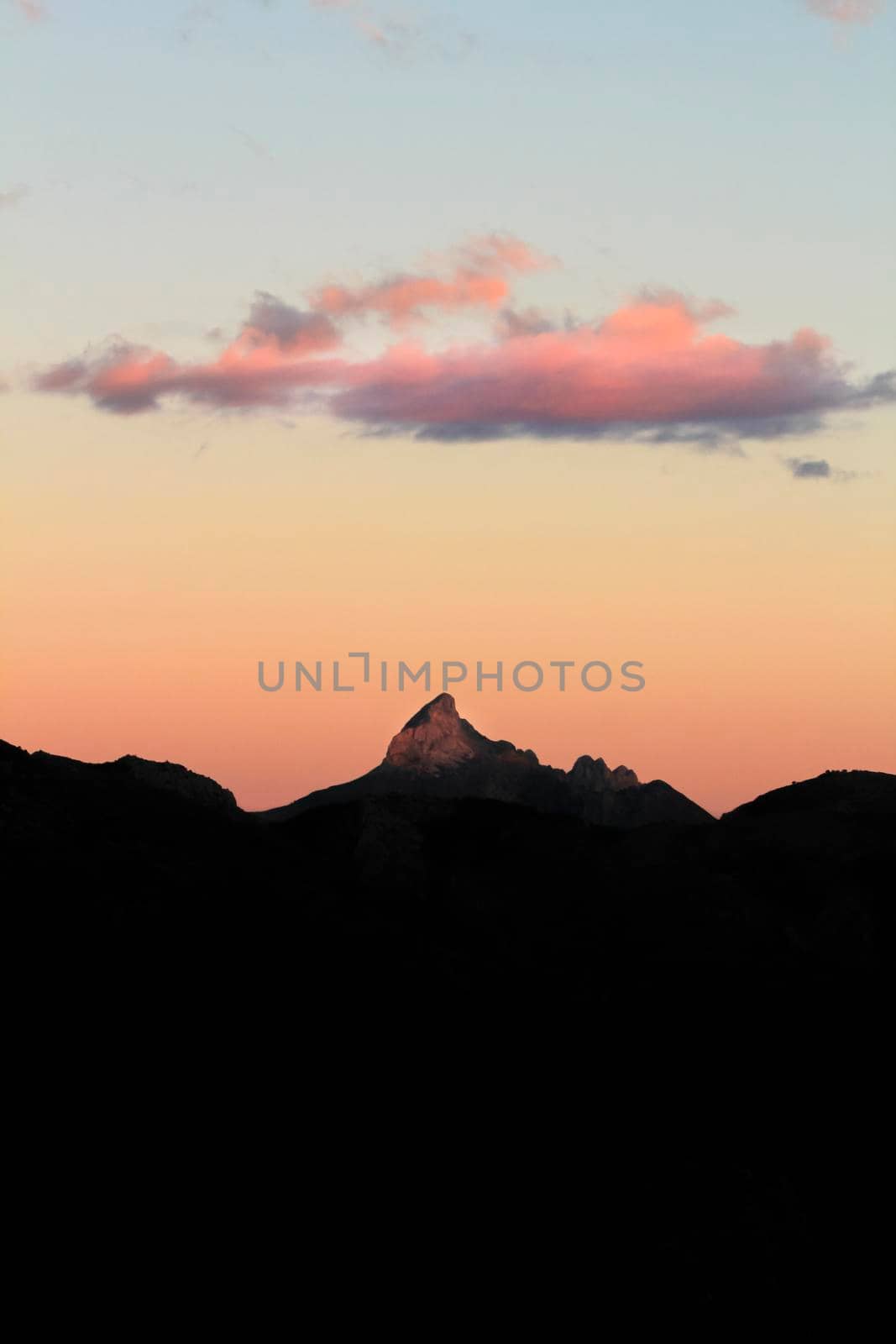 Spectacular sunset with colorful clouds and silhouette of mountains in Guadalest, Alicante, Spain