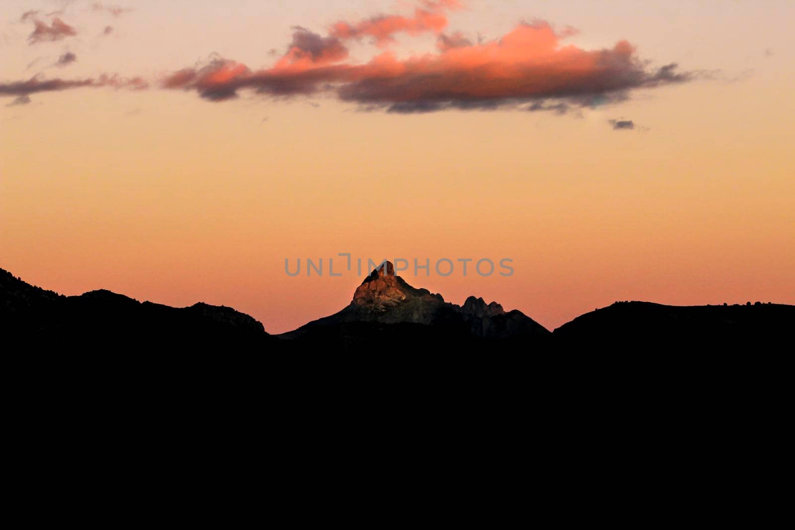 Spectacular sunset with colorful clouds and silhouette of mountains in Guadalest, Alicante, Spain