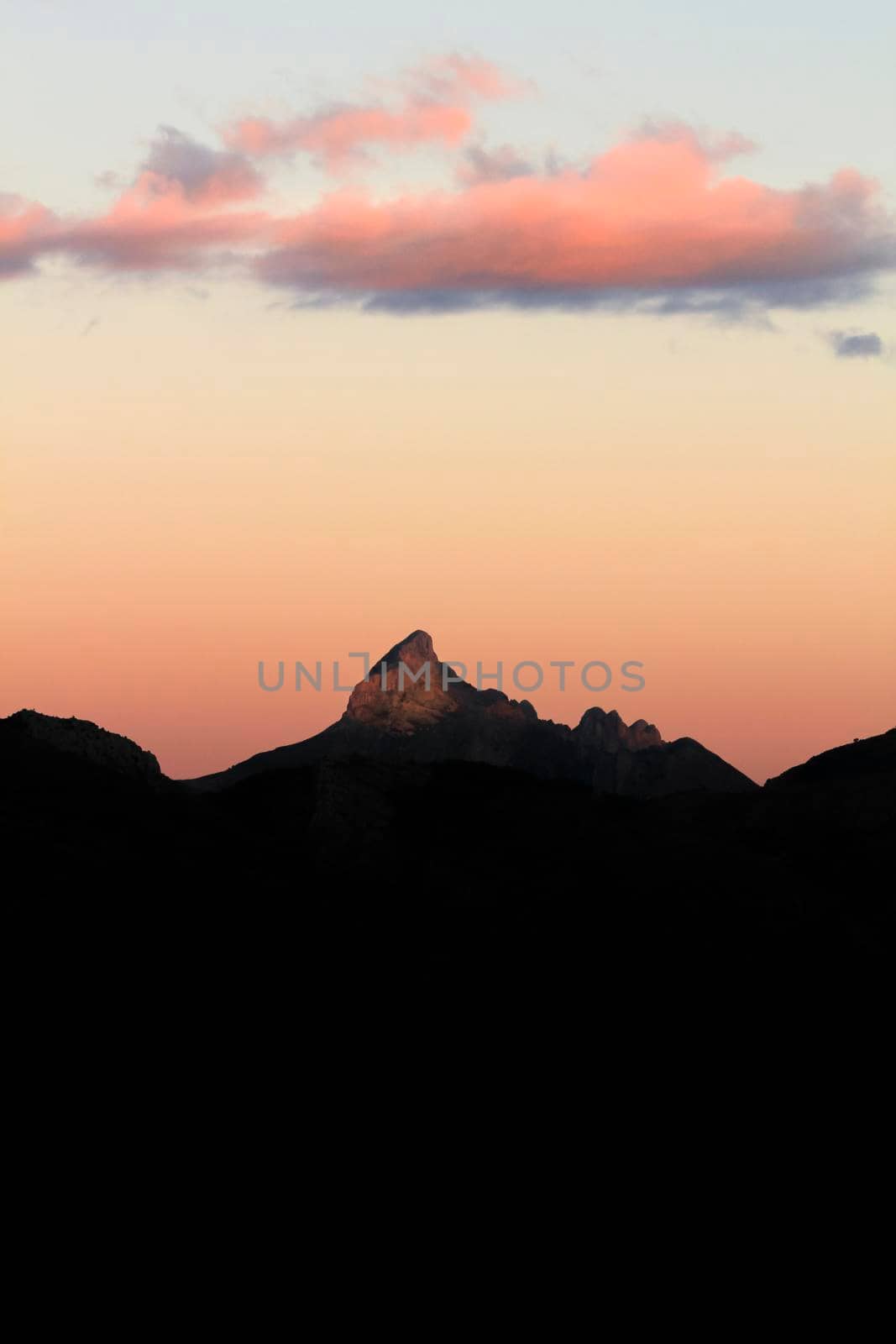 Spectacular sunset with colorful clouds and silhouette of mountains in Guadalest, Alicante, Spain