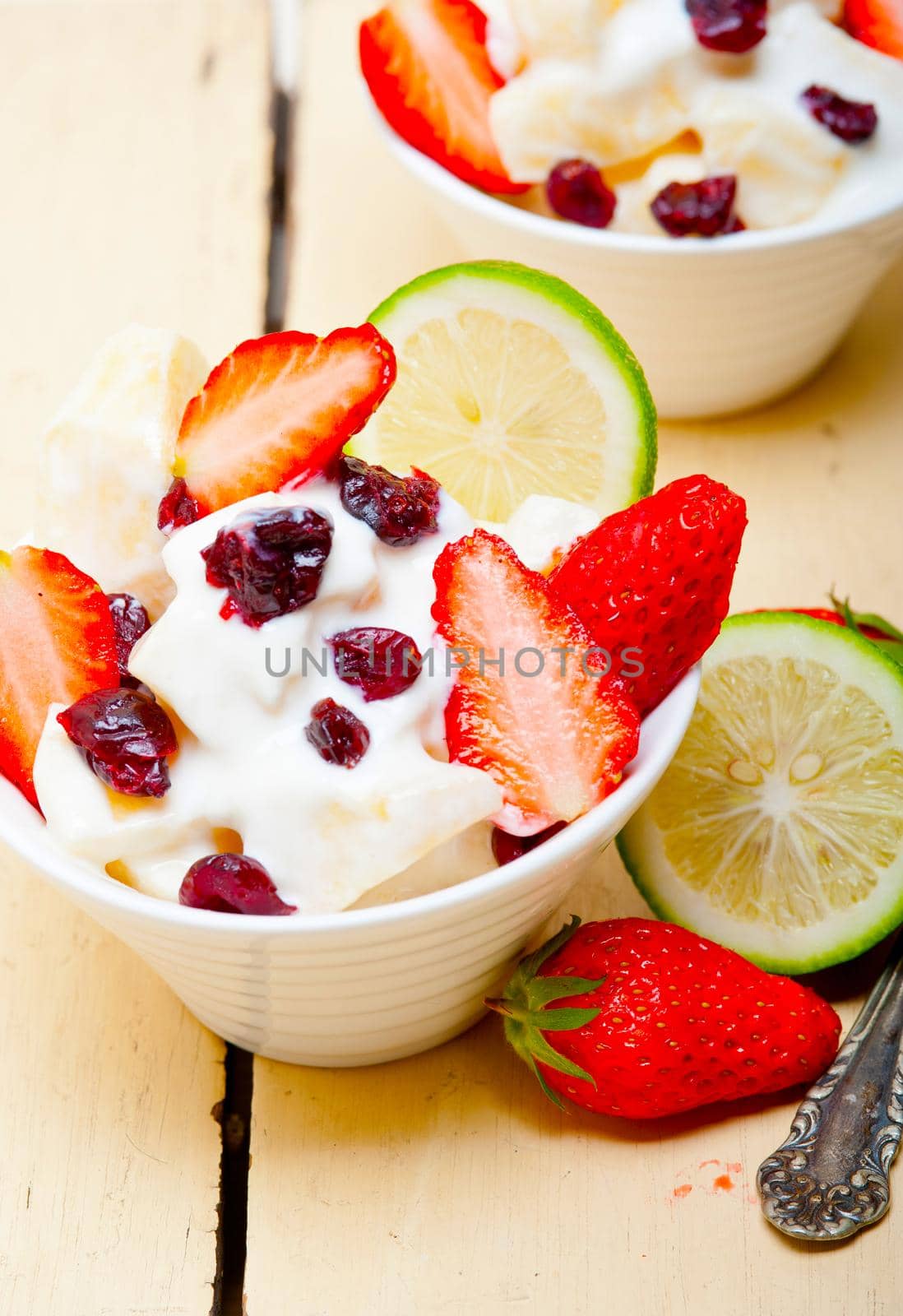 fruit and yogurt salad healthy breakfast over white wood table