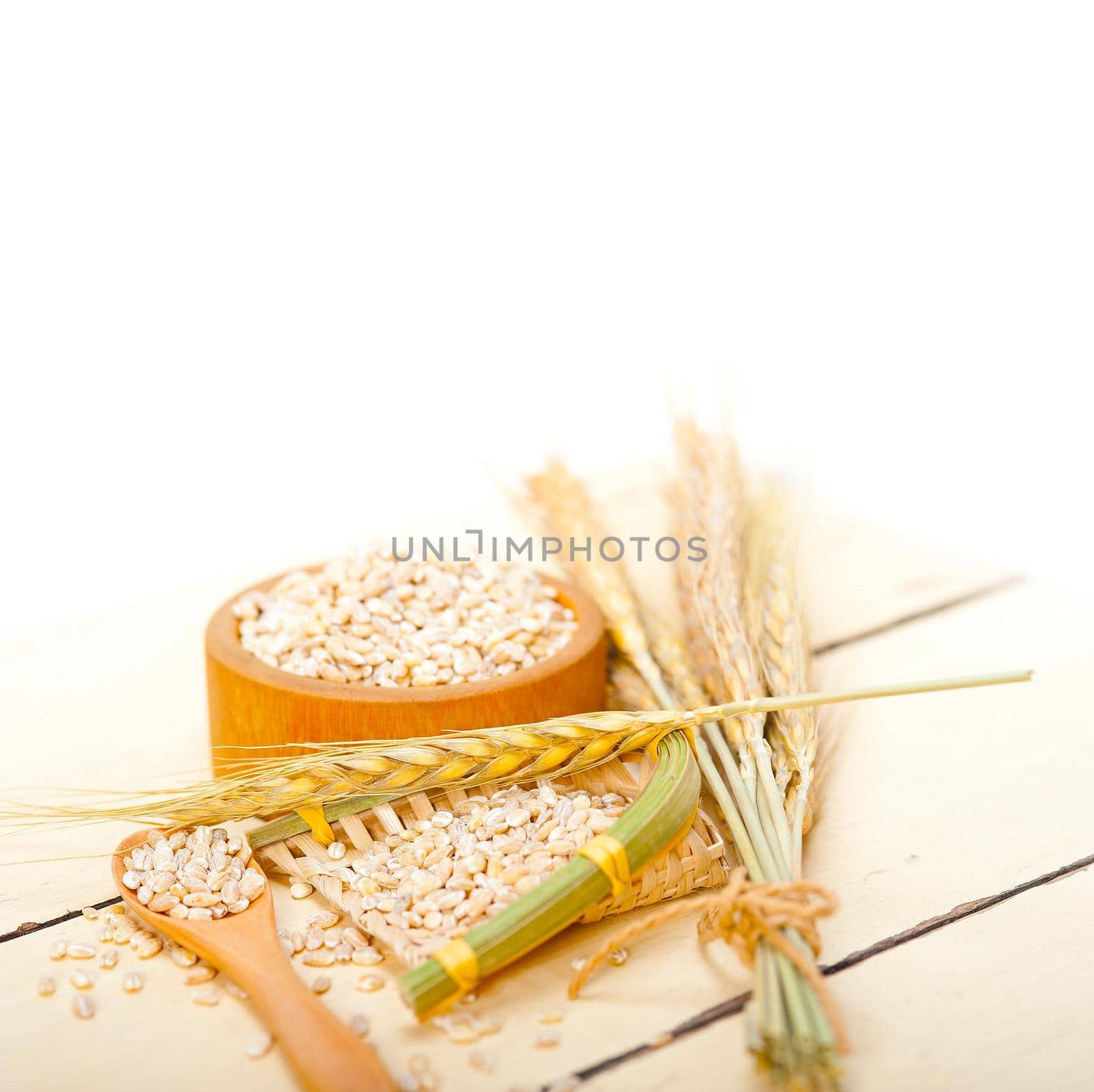 organic wheat grains  over rustic wood table macro closeup