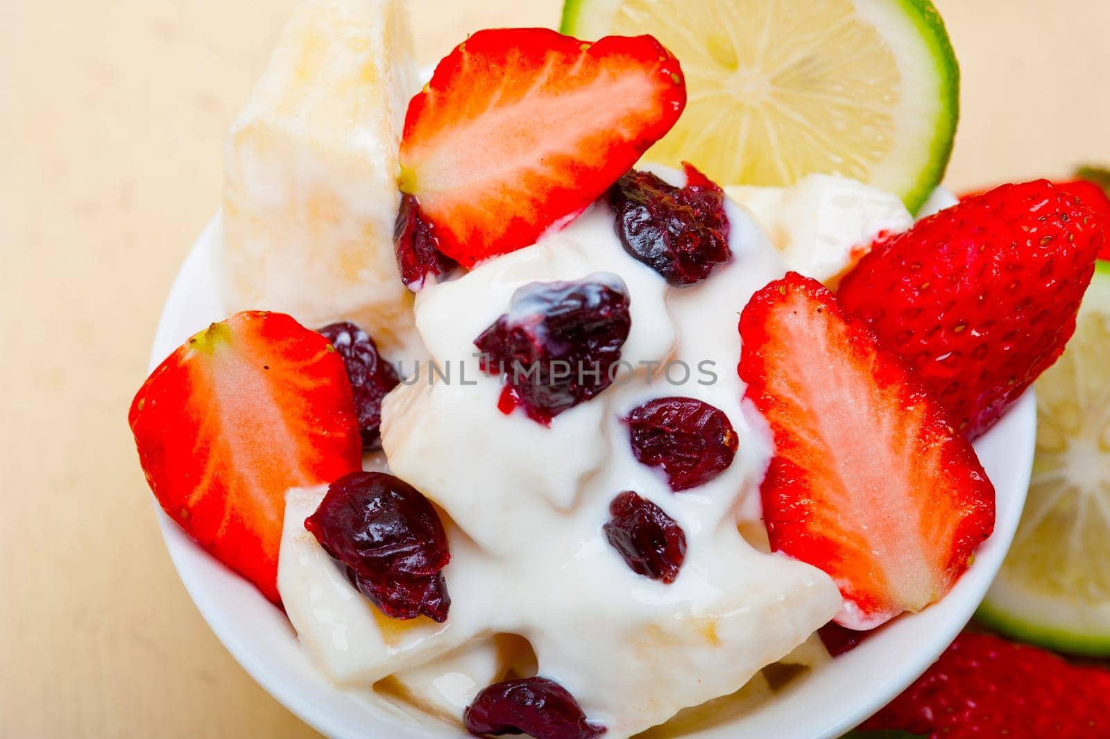 fruit and yogurt salad healthy breakfast over white wood table